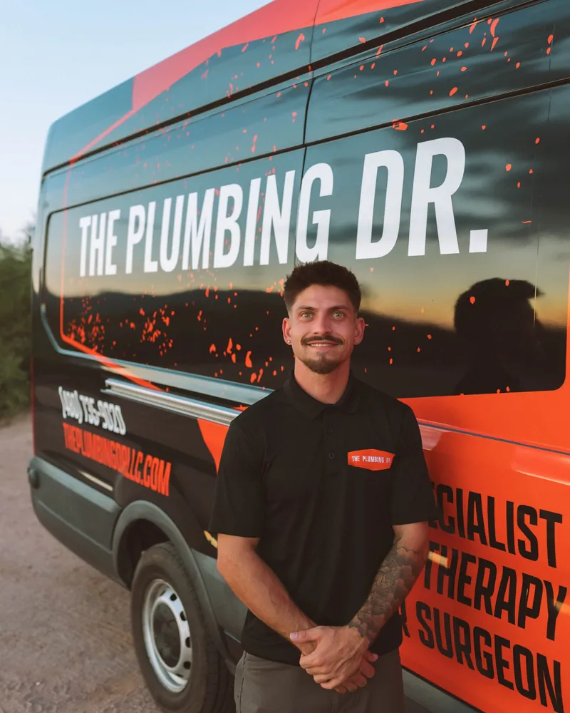 Cameron Balli, owner and lead plumber of The Plumbing Dr., standing in front of a company service van