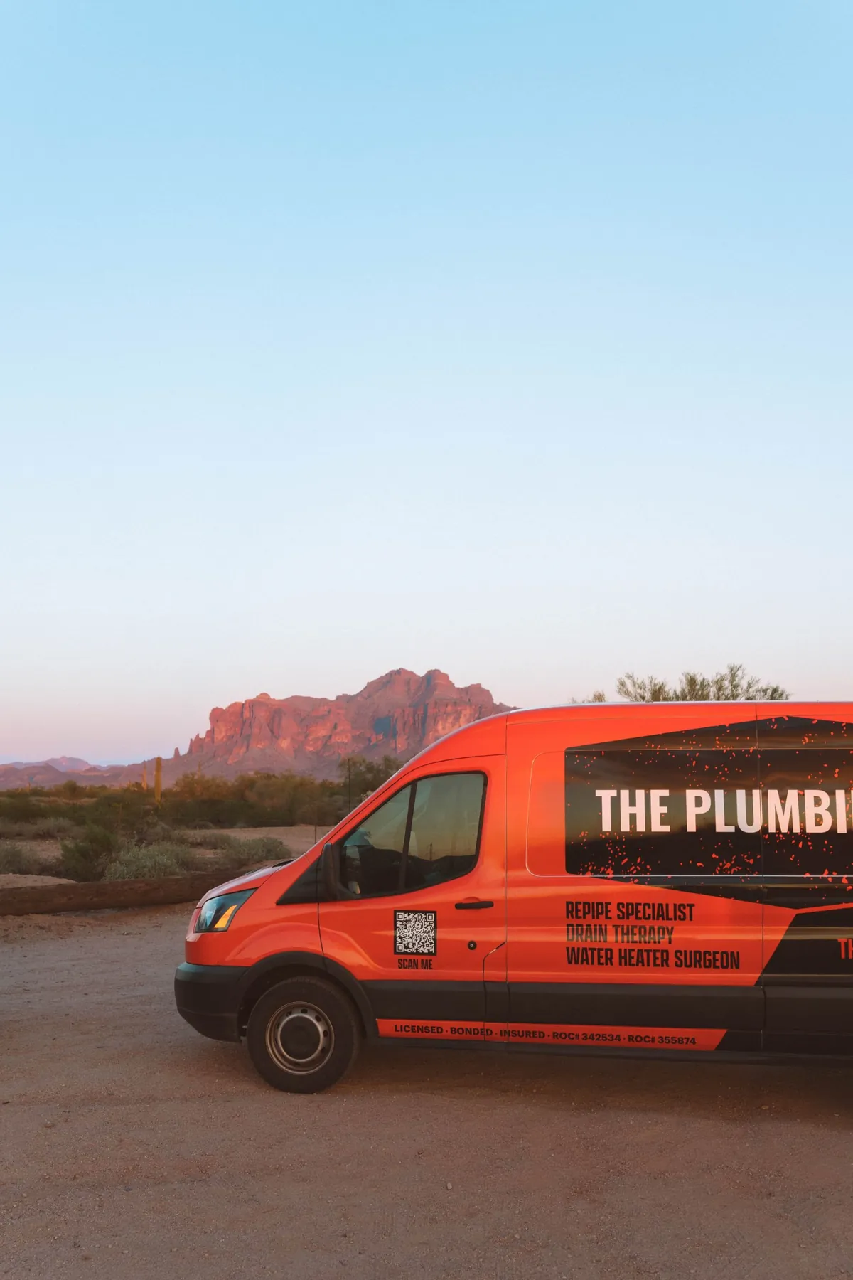 The Plumbing Dr. service van parked in the desert with the Superstition Mountains behind it