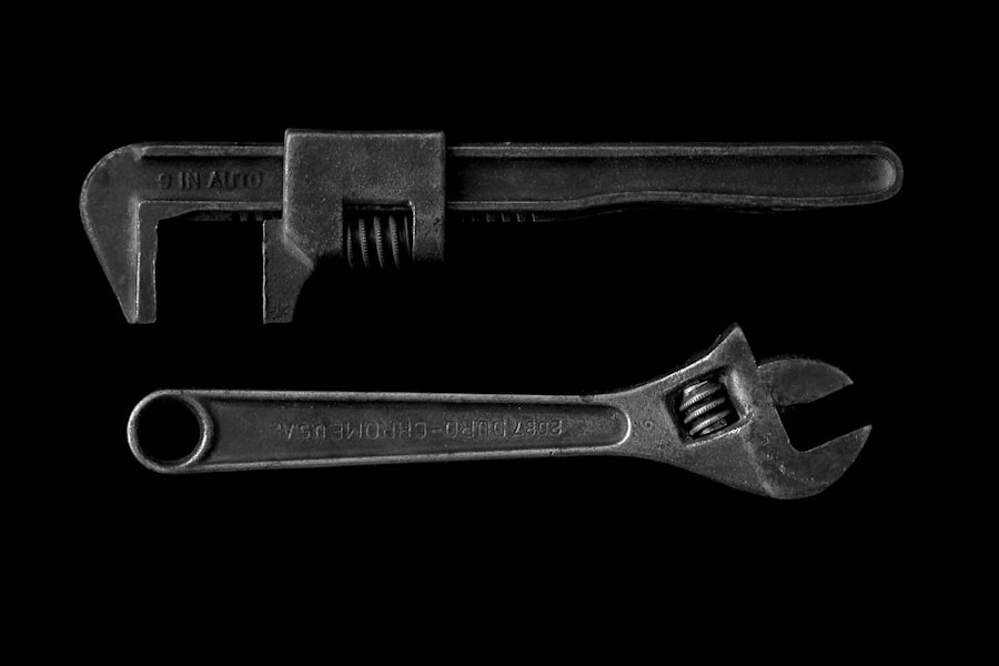 Pipe wrench and adjustable wrench on a dark background.