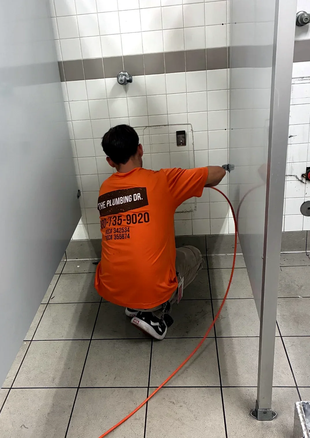 The Plumbing Dr. technician clearing a commercial restroom drain line in Mesa, AZ
