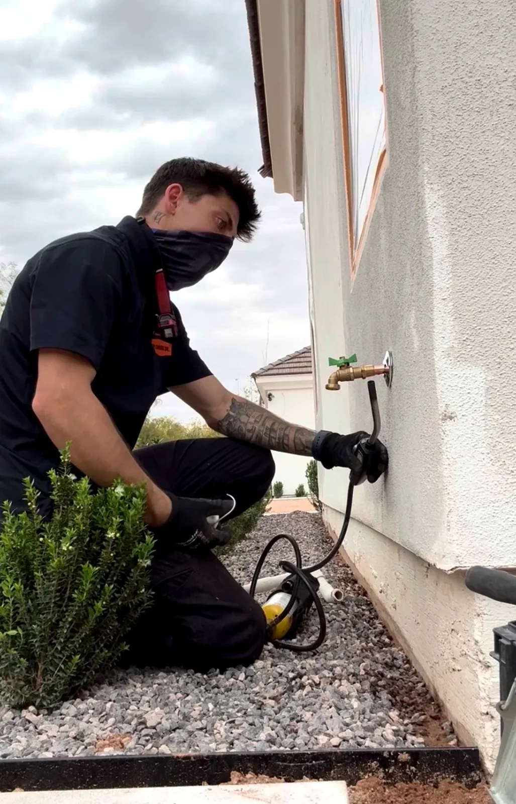 Plumbing technician servicing an outdoor hose bib on a Mesa, AZ home