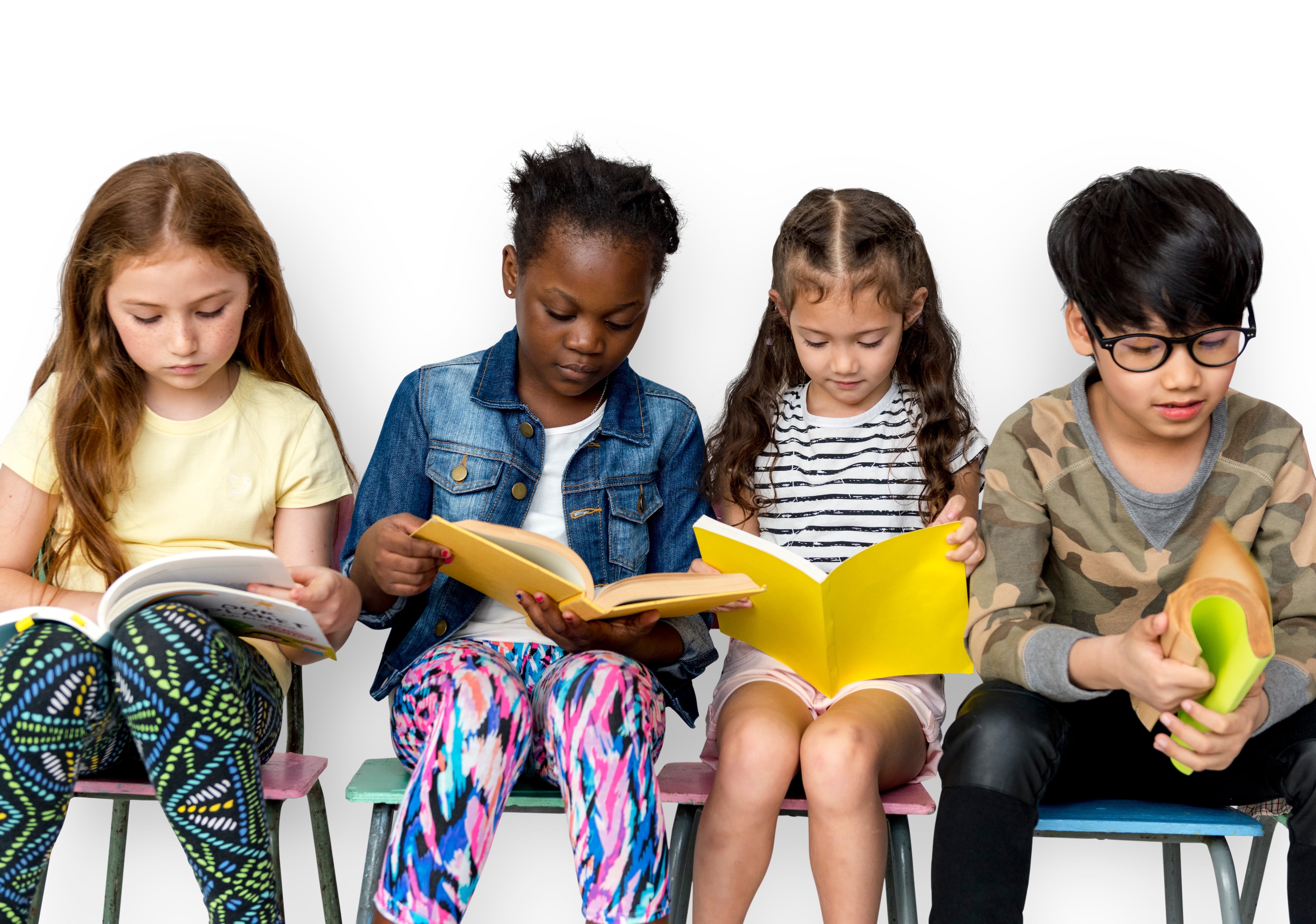 Four diverse children seated side by side on colorful chairs, focused on reading books of different colors and sizes against a plain white background.