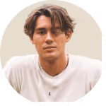 Young man with medium-length dark hair wearing a white shirt, looking at the camera.
