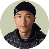Portrait of a young man wearing a black beanie and a dark jacket with a light background.