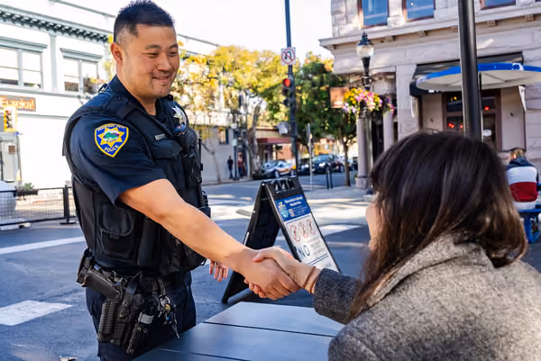 A Mountain View police officer shaking hands with a community member