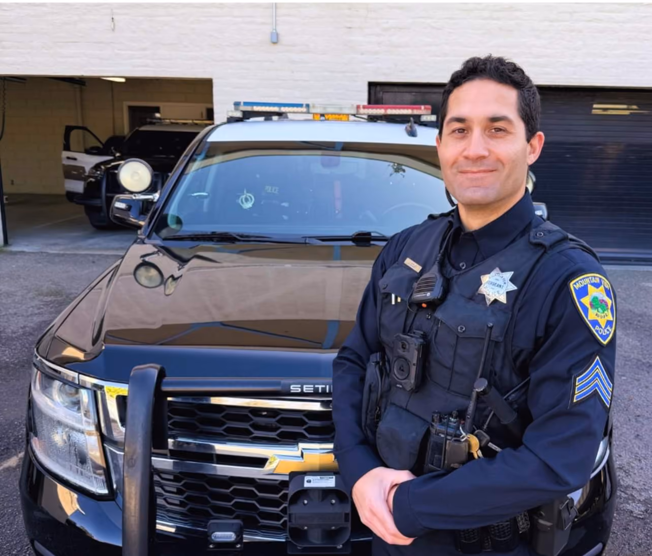 A Mountain View police officer standing beside a patrol SUV
