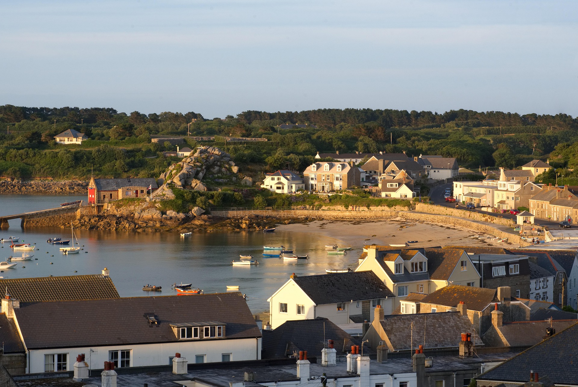 Boats moored in a sheltered harbor town at low tide