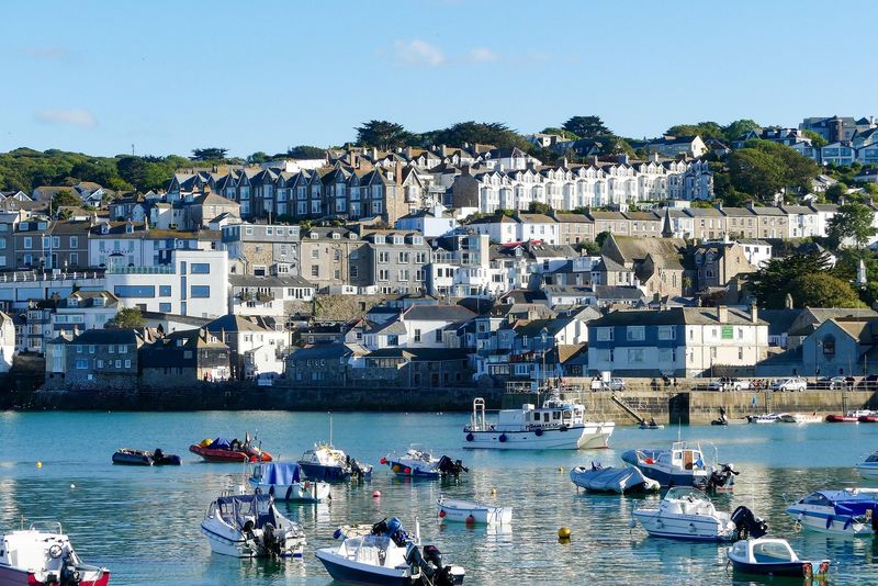 Fishing boats resting in a tidal harbor beside a stone quay