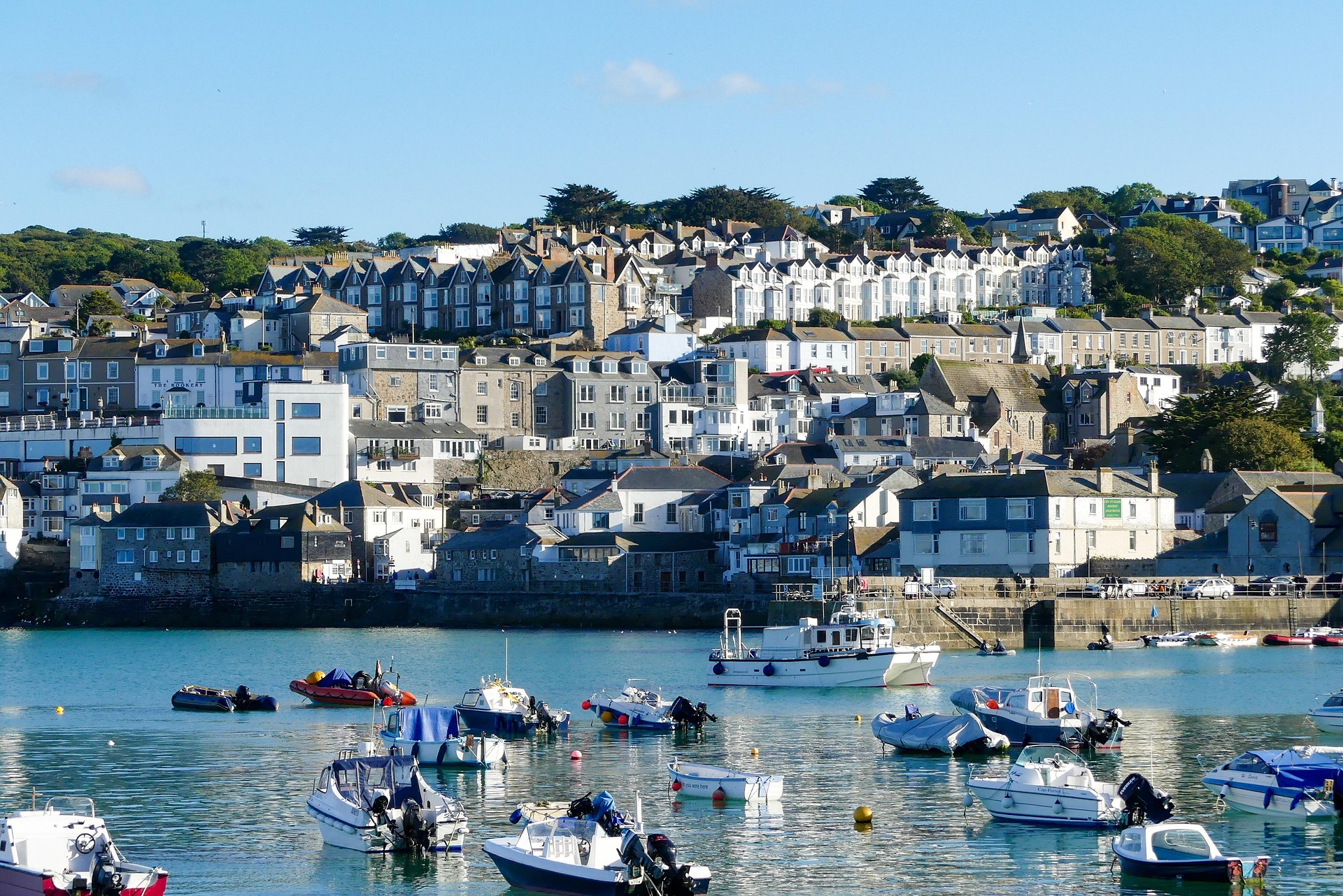 Fishing boats resting in a tidal harbor beside a stone quay