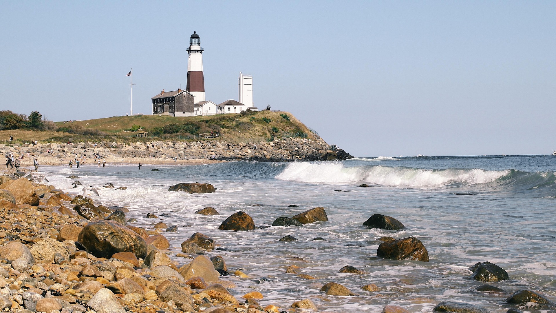A lighthouse standing on a rocky New England shoreline