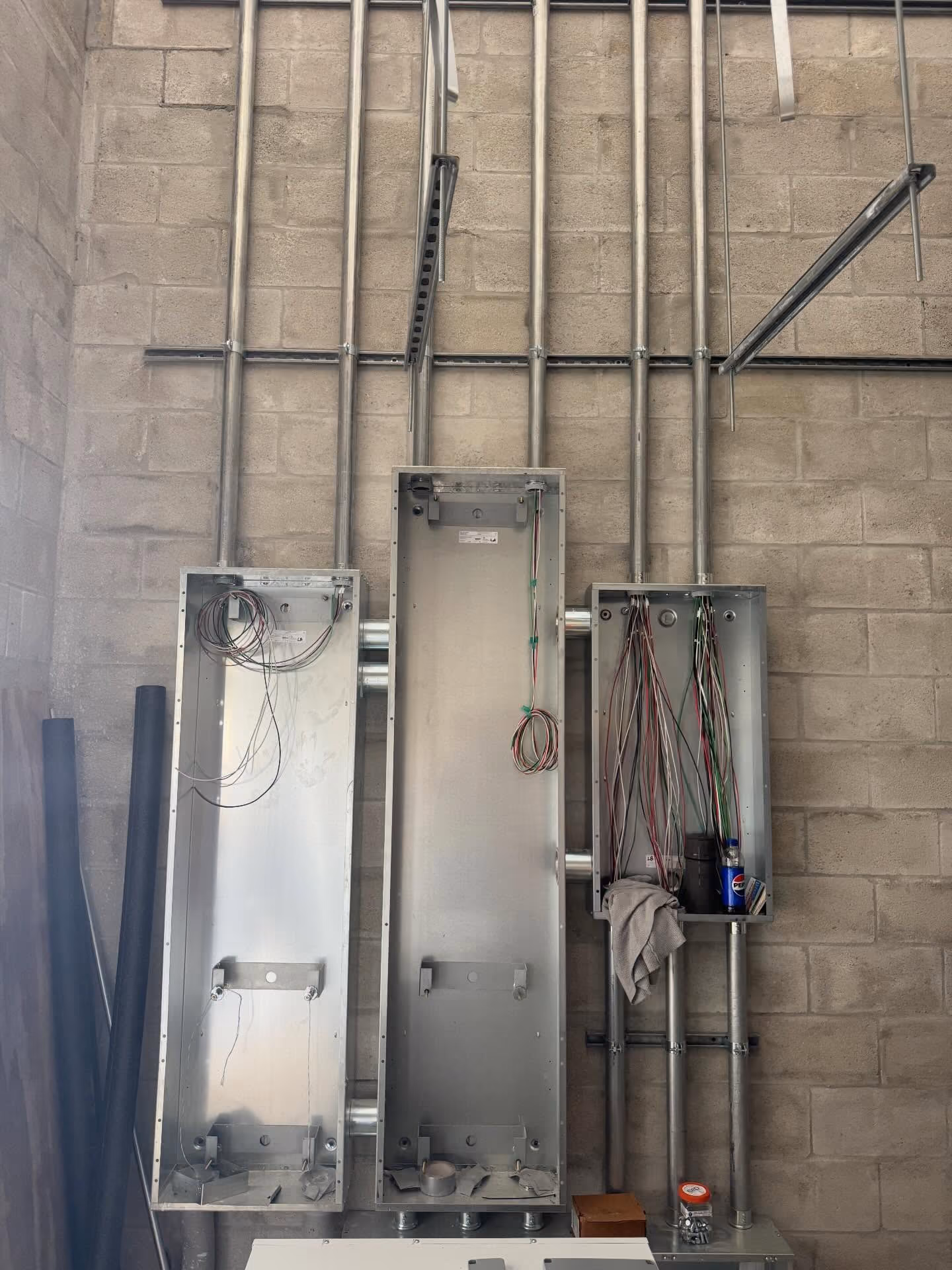 Commercial electrical panel enclosures with organized wiring and conduit.
