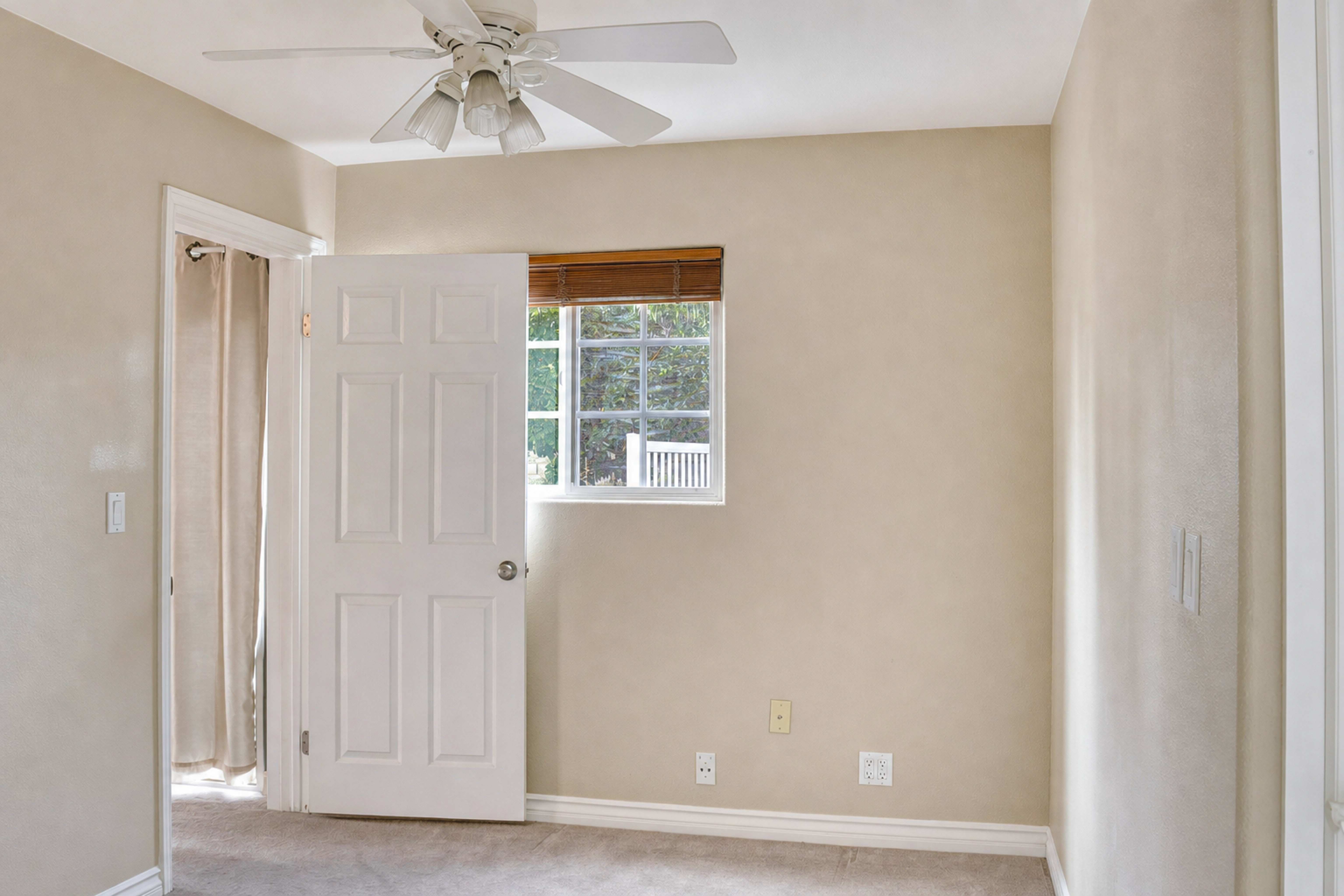 Bright unfurnished bedroom with garden window and ceiling fan, Anaheim rental property