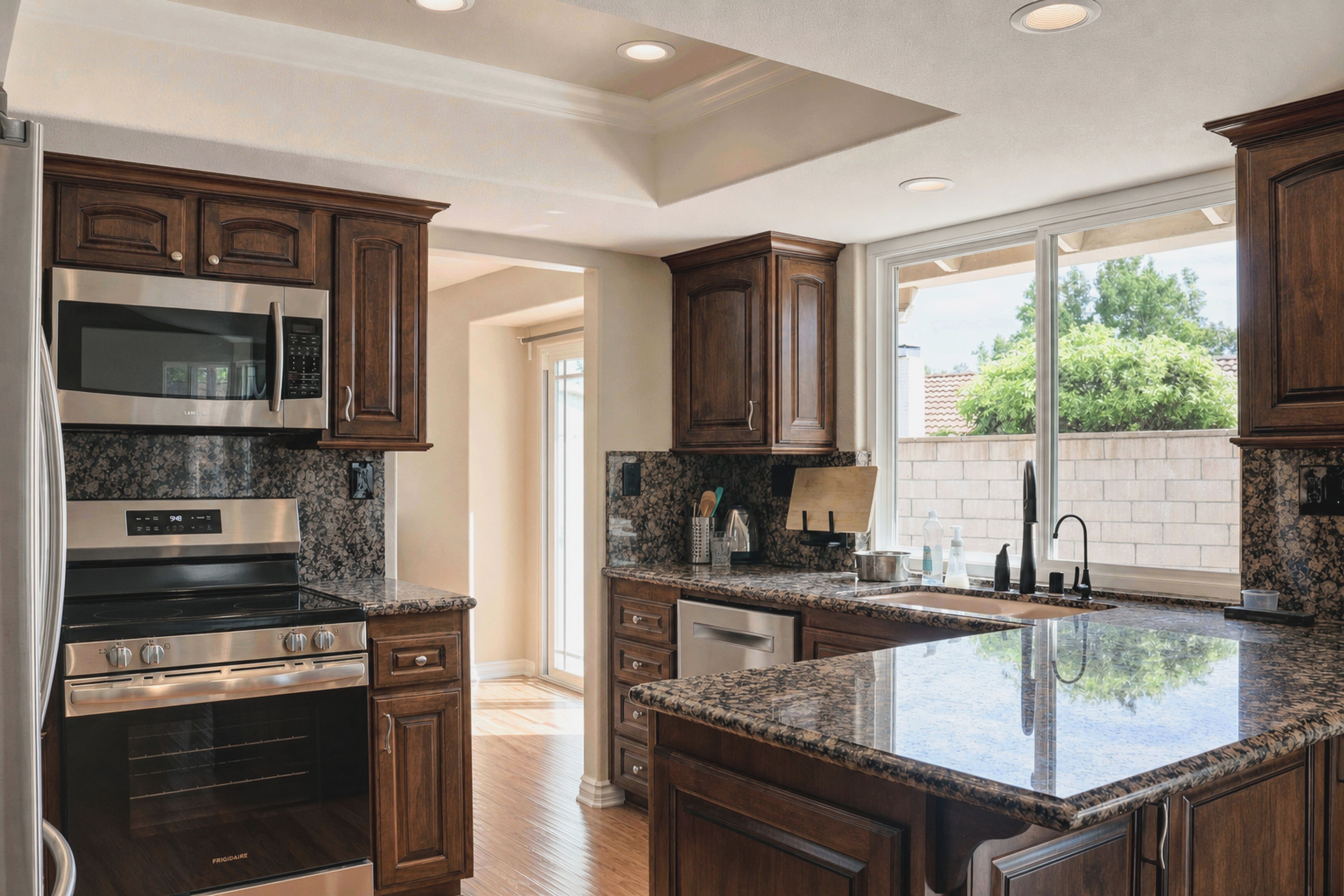 Kitchen with dark wood cabinetry, granite counters and stainless appliances, Anaheim rental home