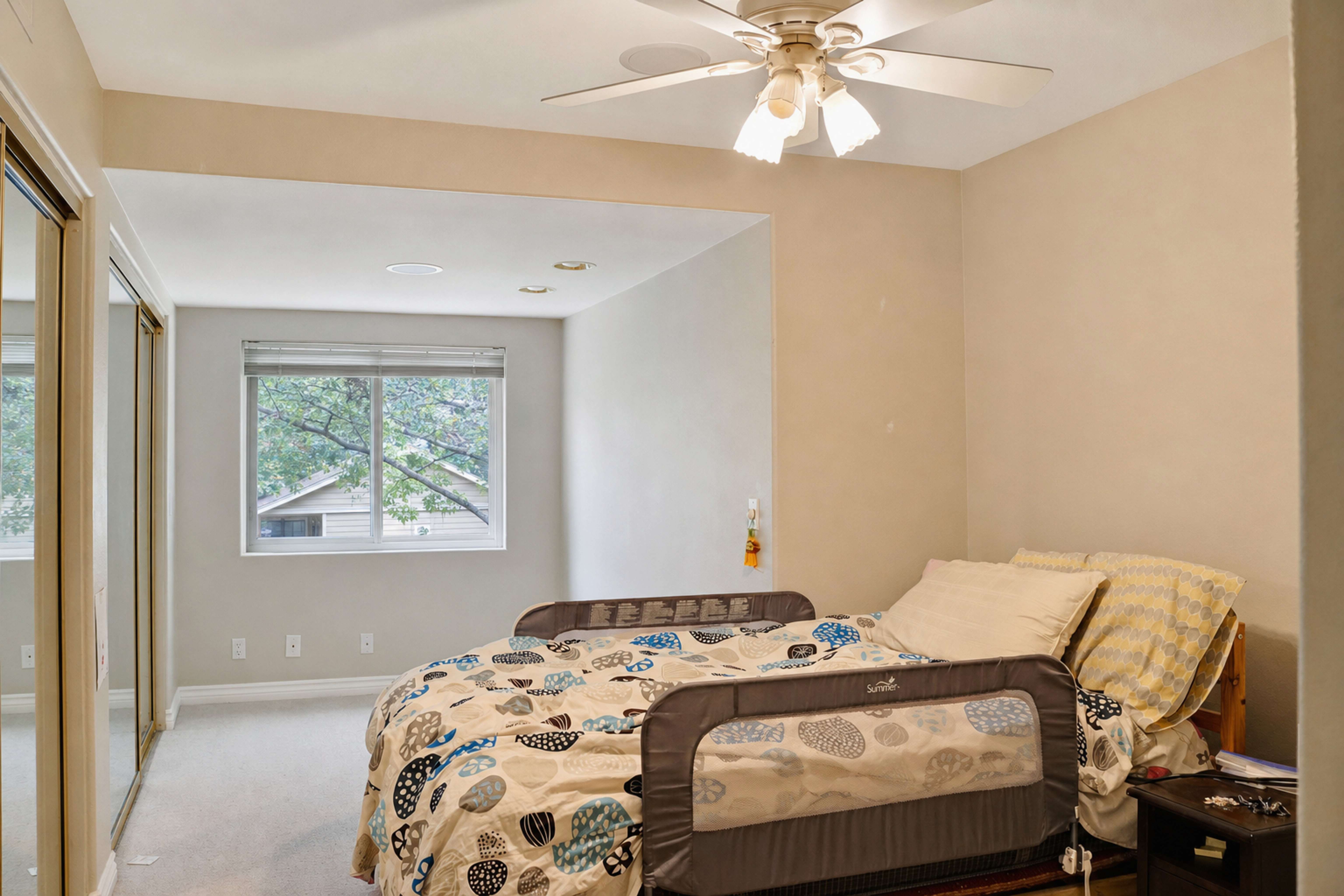 Furnished guest bedroom with window and ceiling fan, Anaheim short-term rental