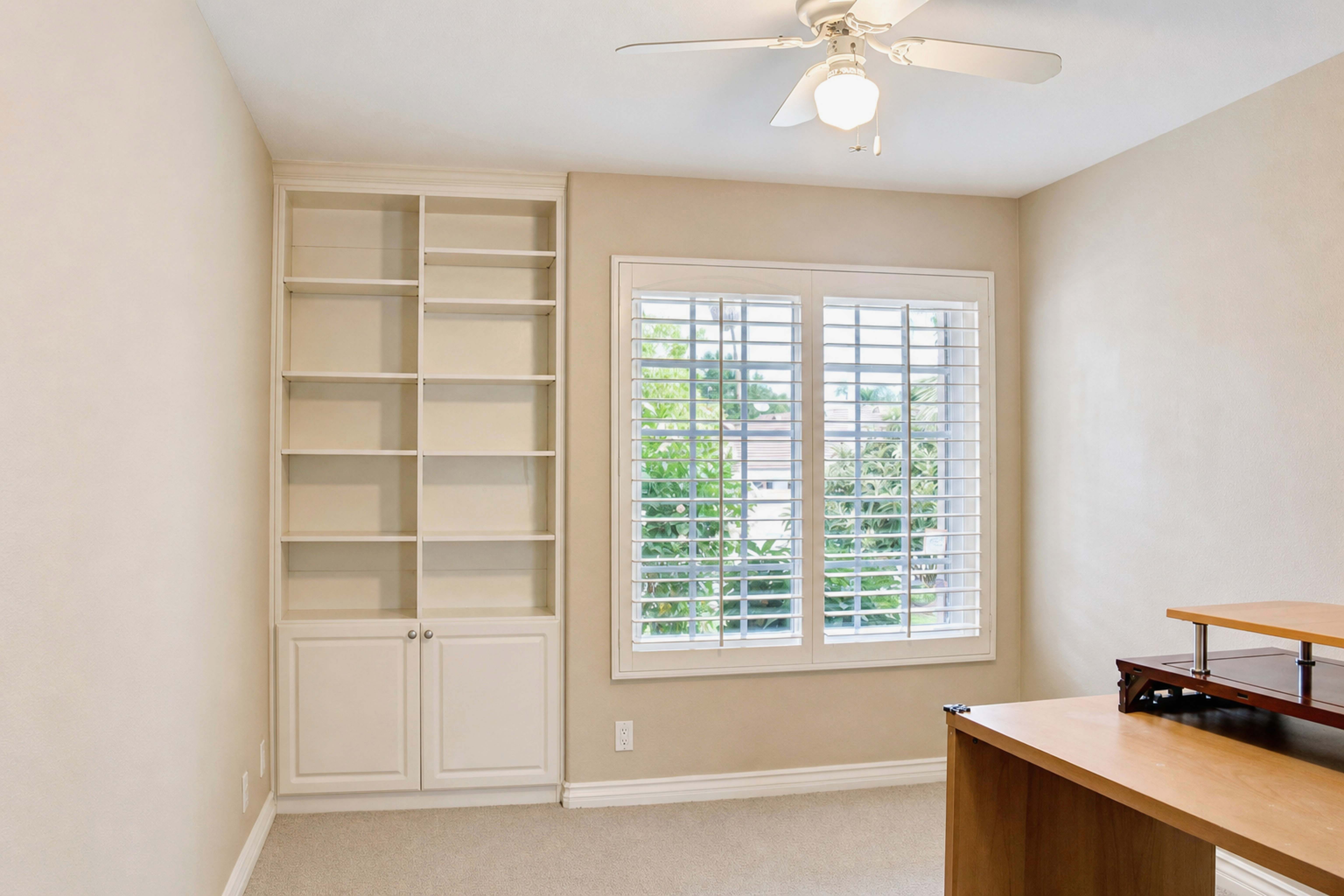 Room with built-in shelving and plantation-shuttered window, Anaheim short-term rental