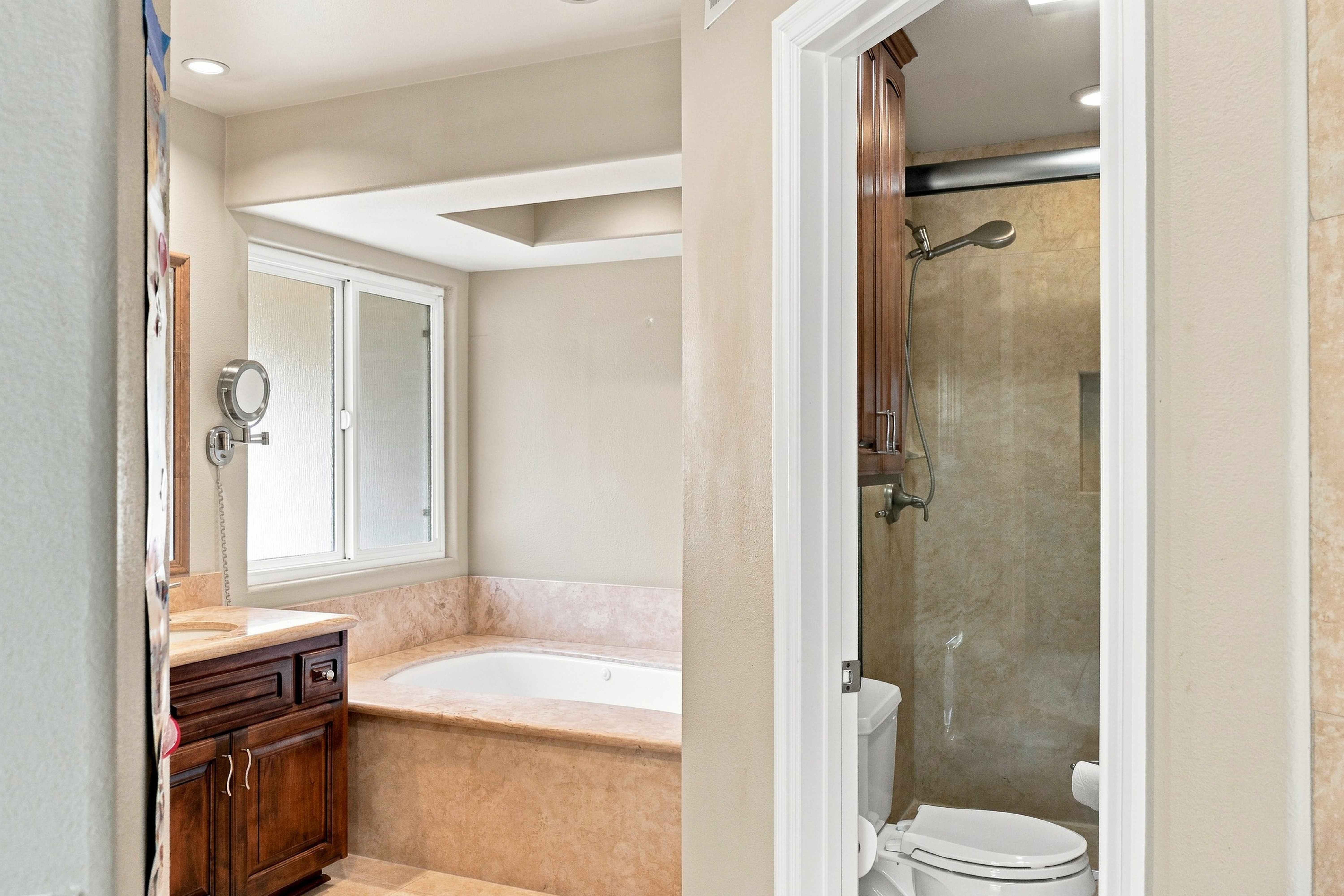 Bathroom with soaking tub, glass shower enclosure and wood vanity, Anaheim short-term rental