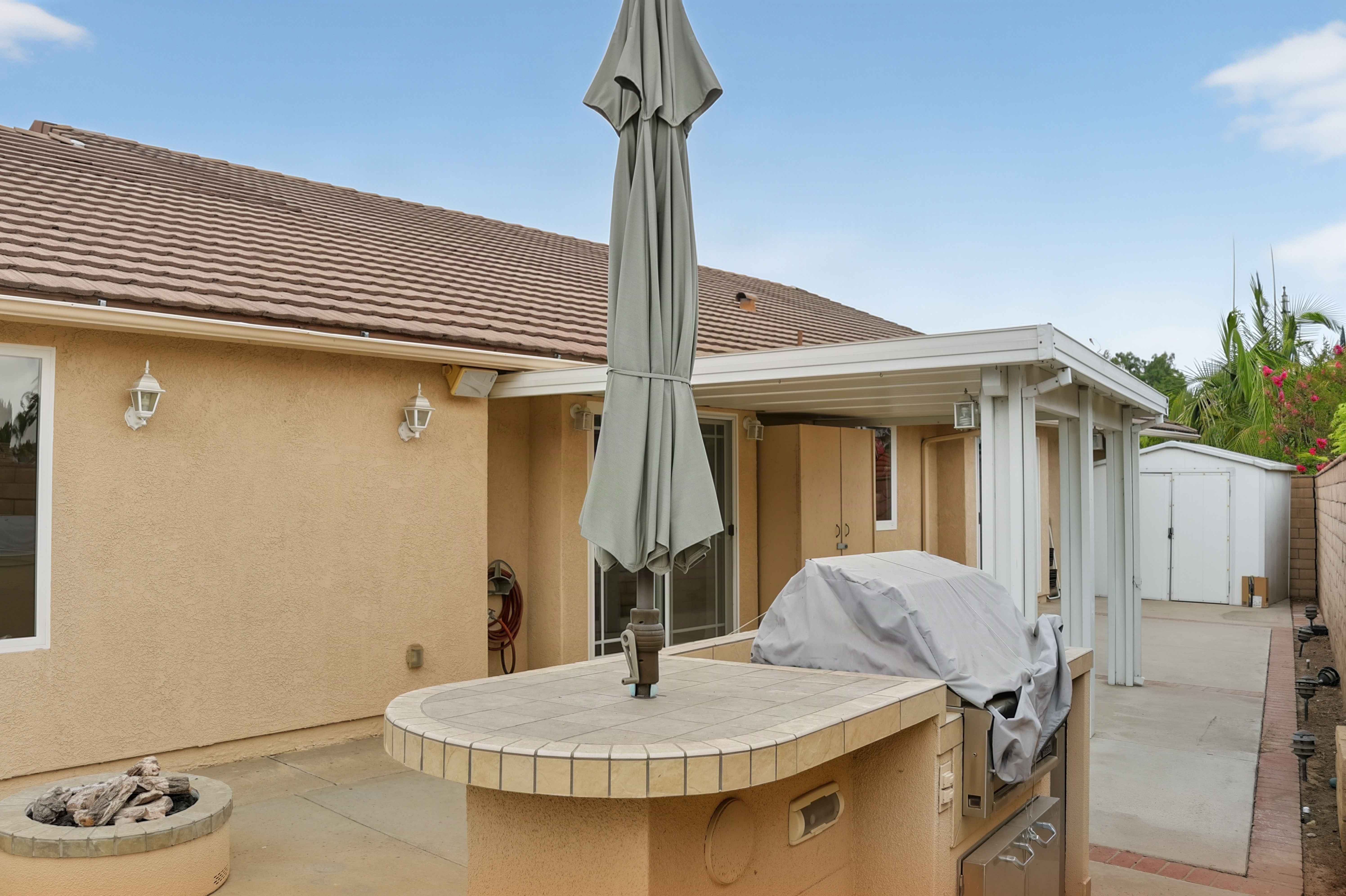 Covered patio with built-in barbecue island and umbrella seating, Anaheim vacation rental