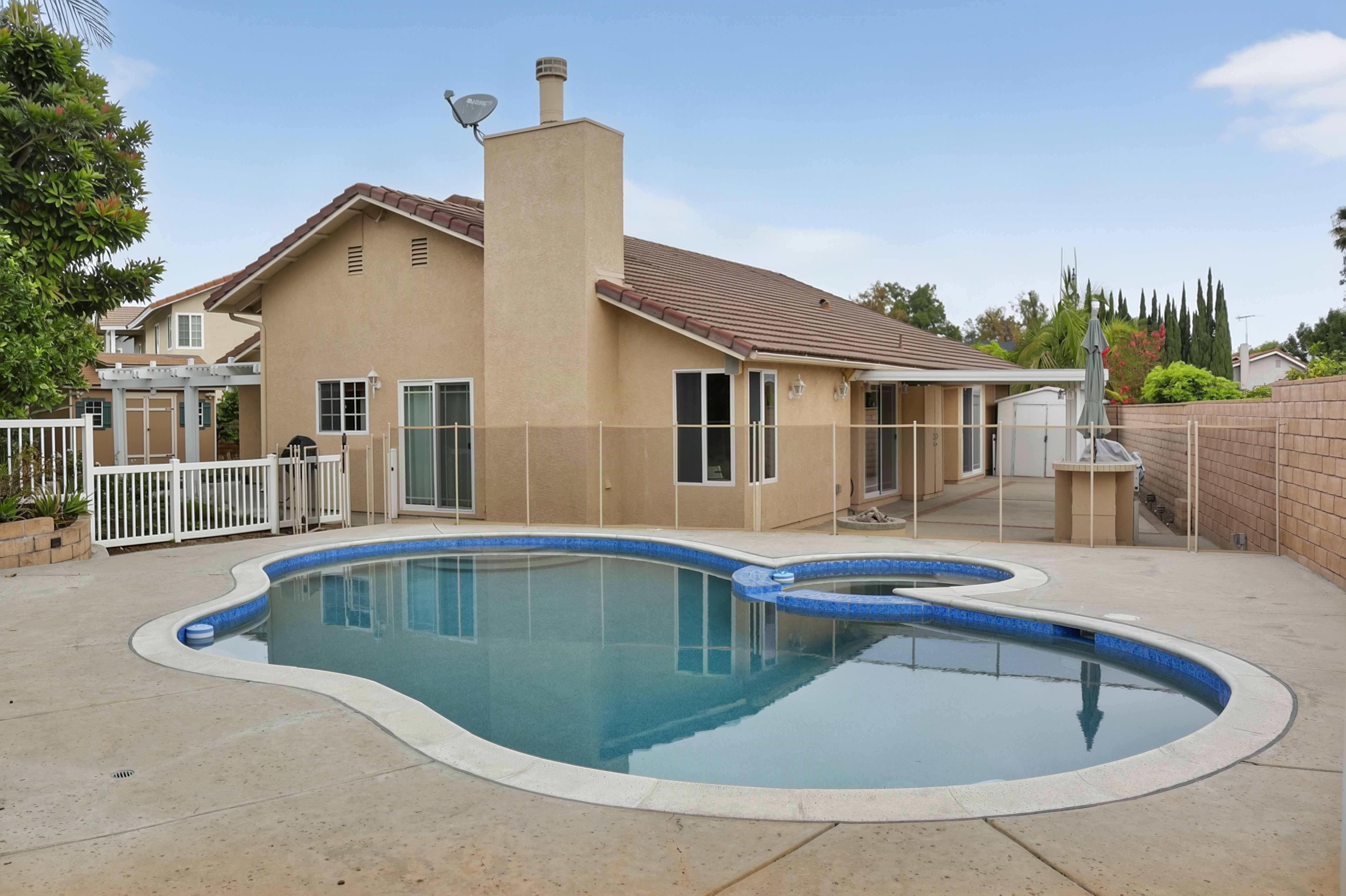 Backyard swimming pool and spa with paved deck, Anaheim short-term rental