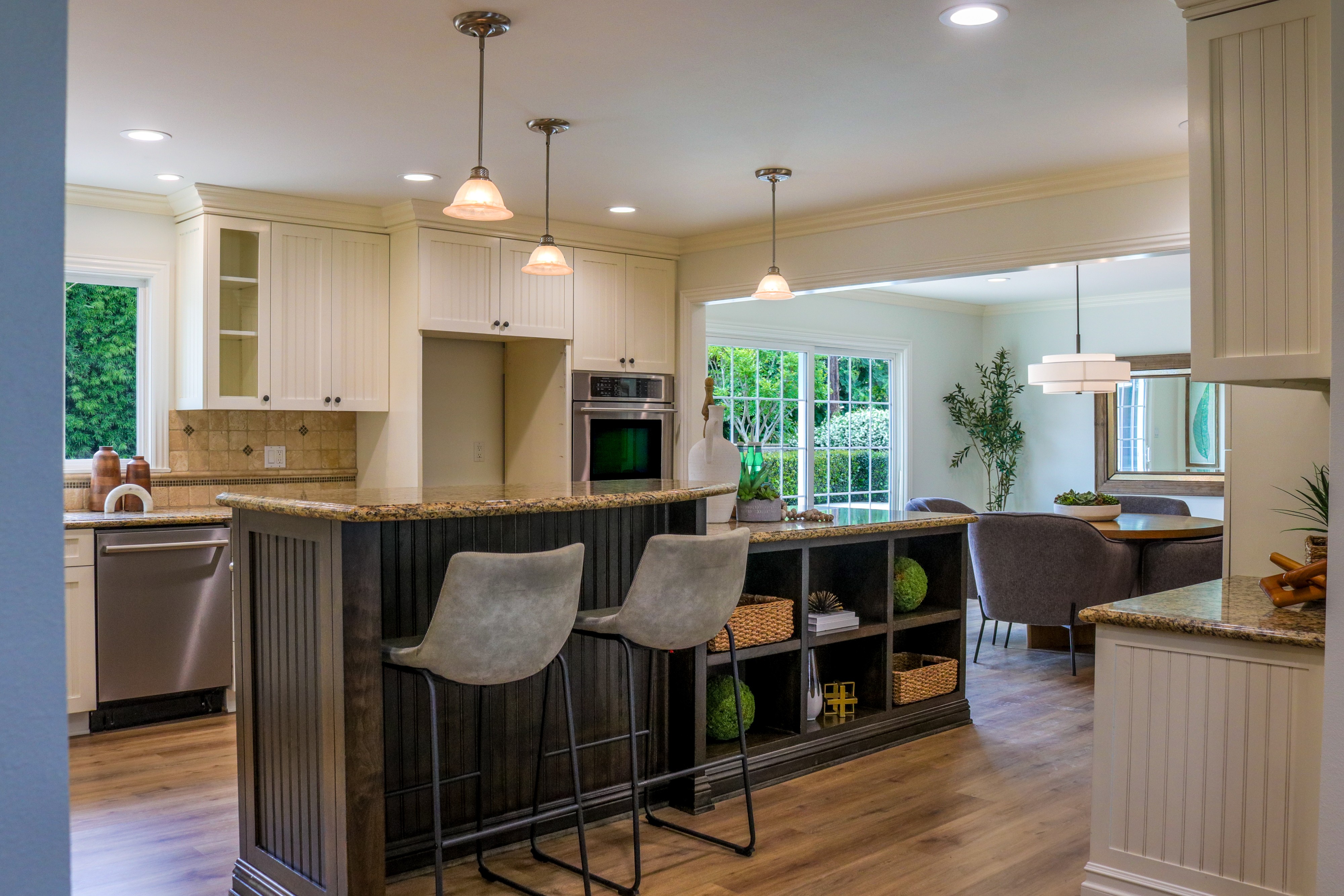 Kitchen island with bar seating, open shelving and pendant lighting, Tustin residential listing