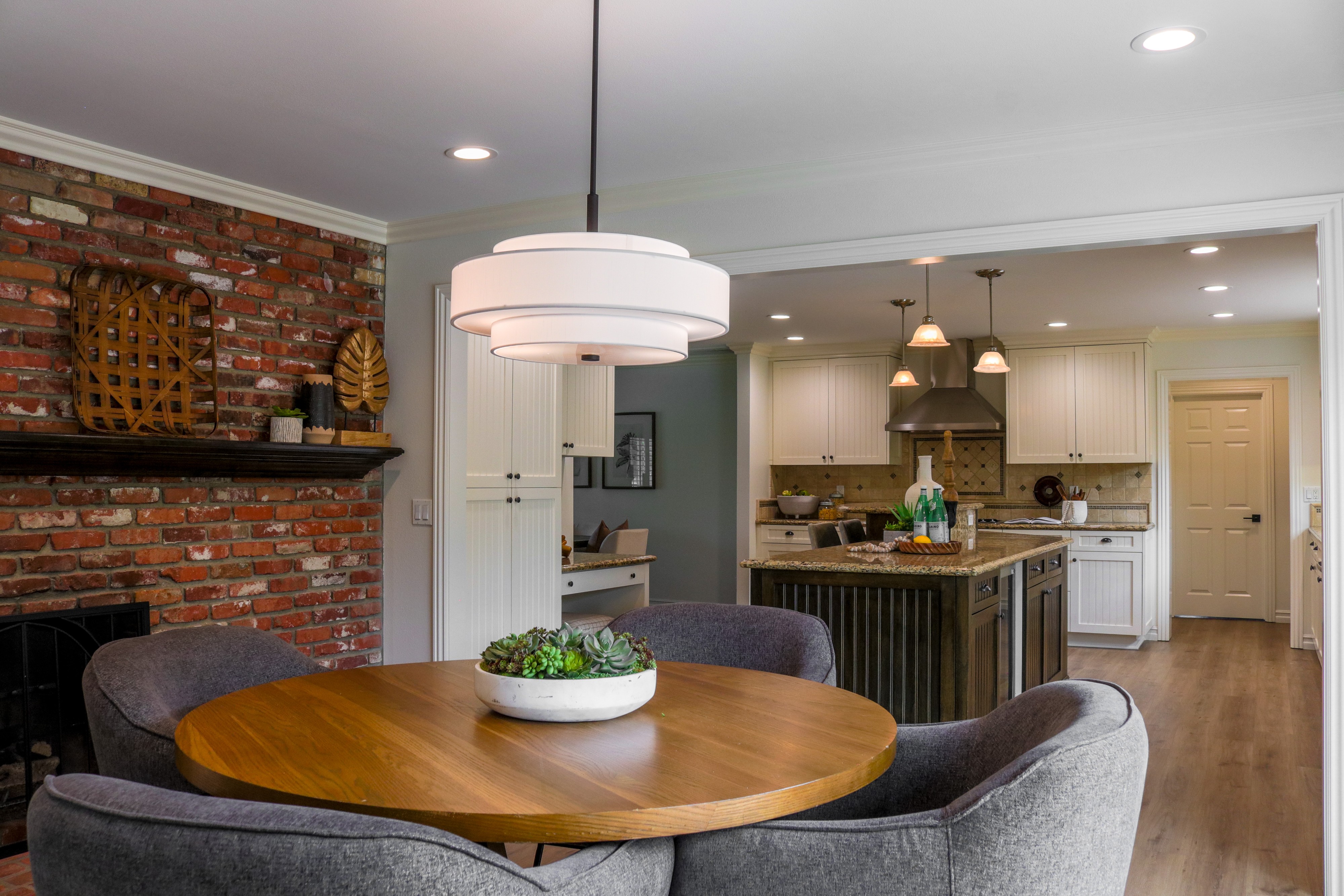 Dining area with exposed brick fireplace open to the kitchen, Tustin residential listing