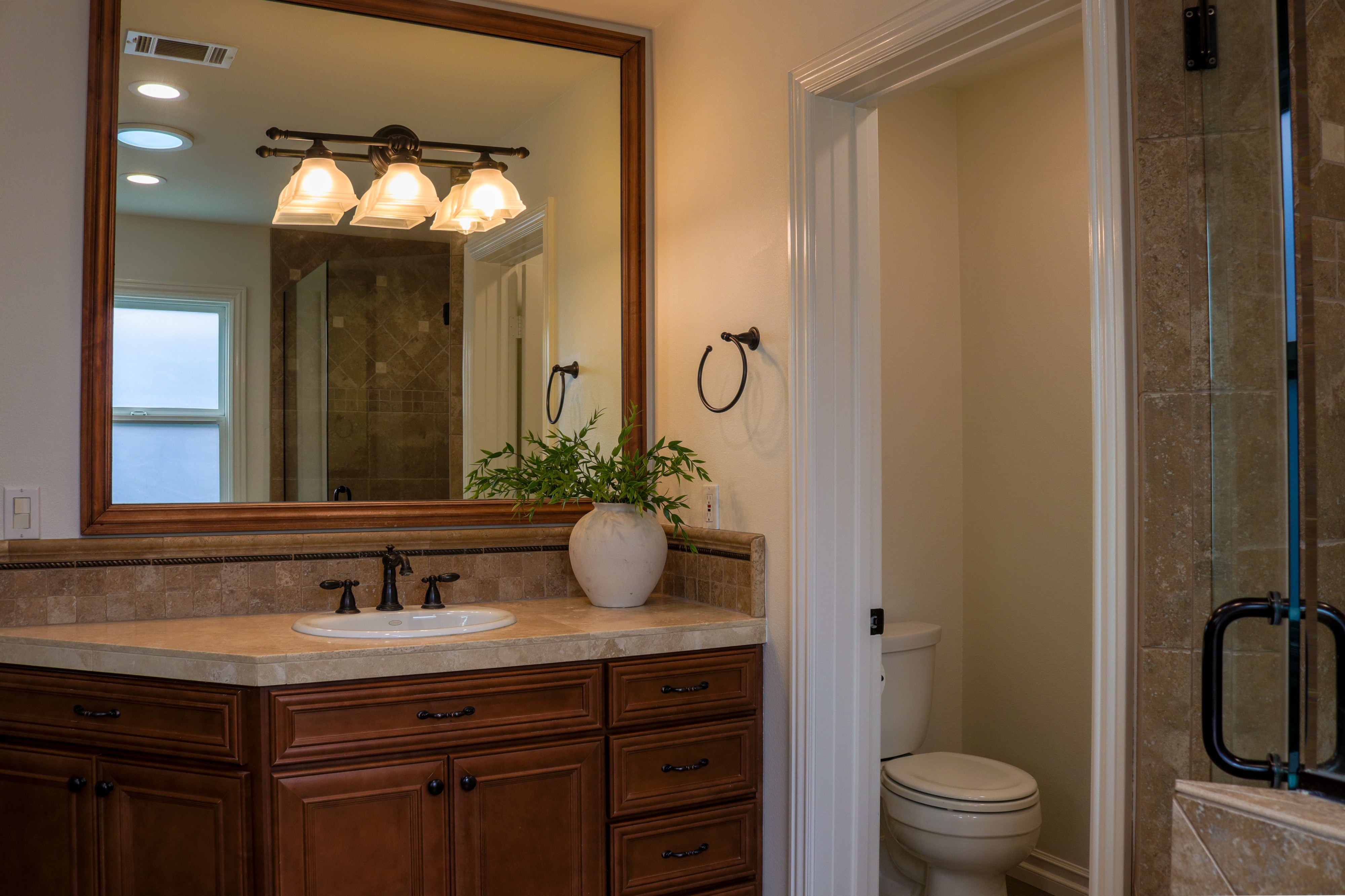 Bathroom vanity with framed mirror and sconce lighting, Tustin residential listing
