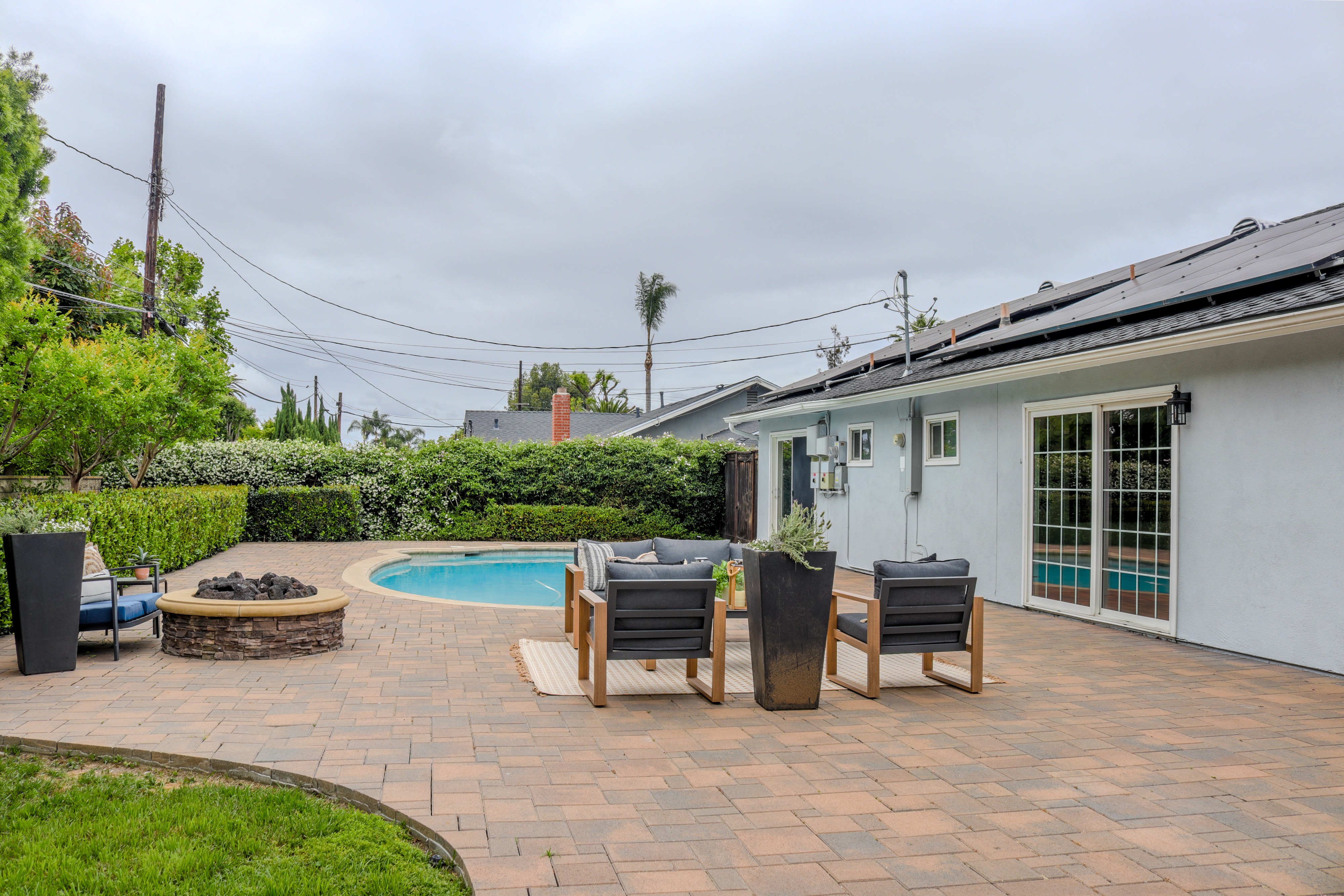 Backyard fire pit and patio seating with pool beyond, Tustin residential listing