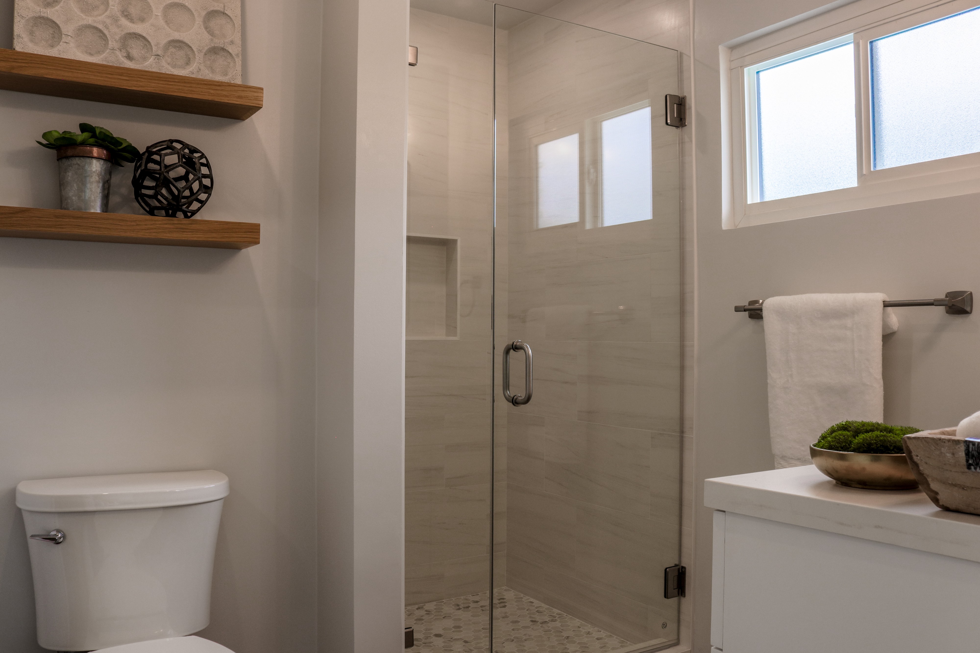 Bathroom with frameless glass shower and floating shelves, Tustin home for sale