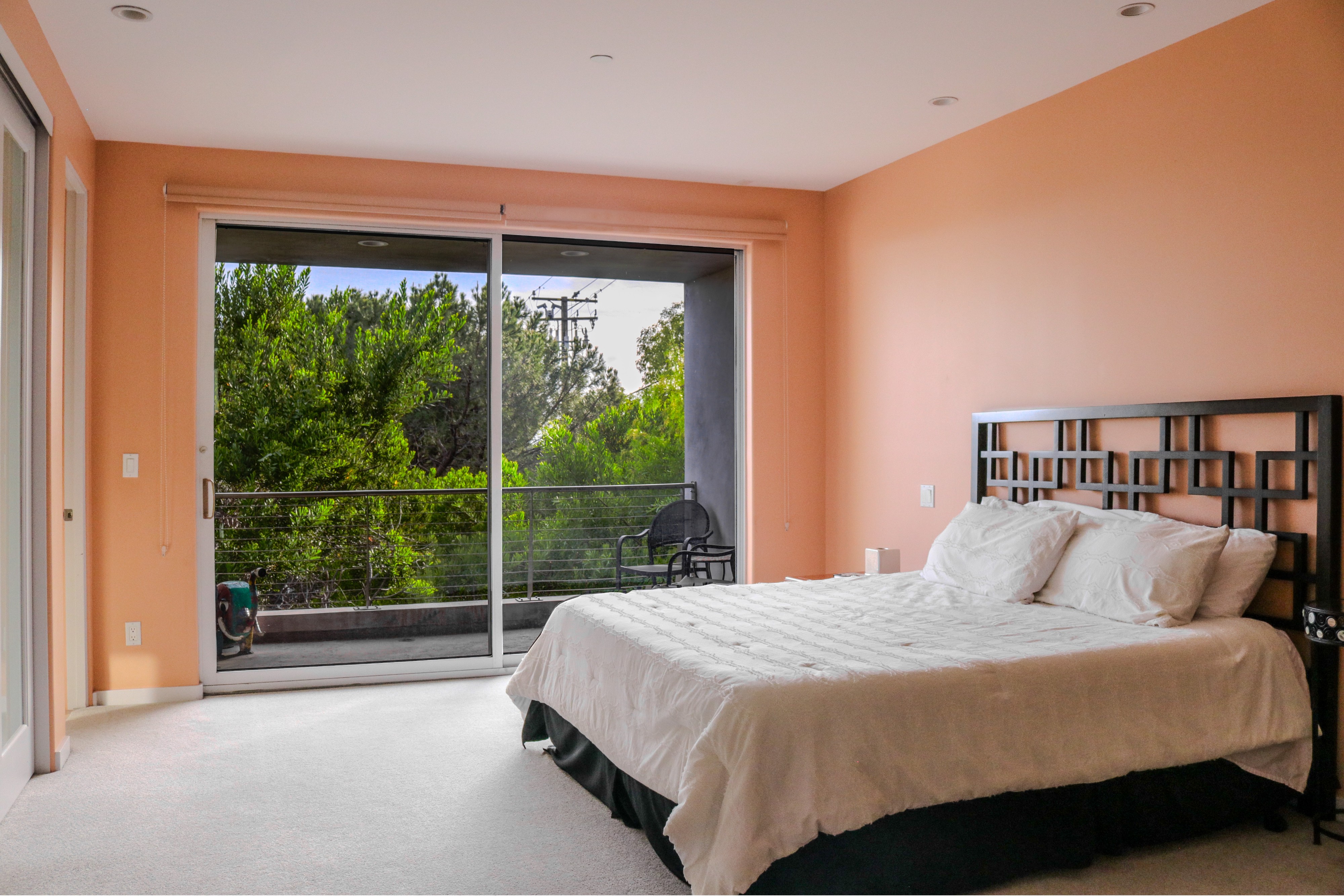 Guest bedroom with sliding glass door opening to the hillside view, Tustin luxury home