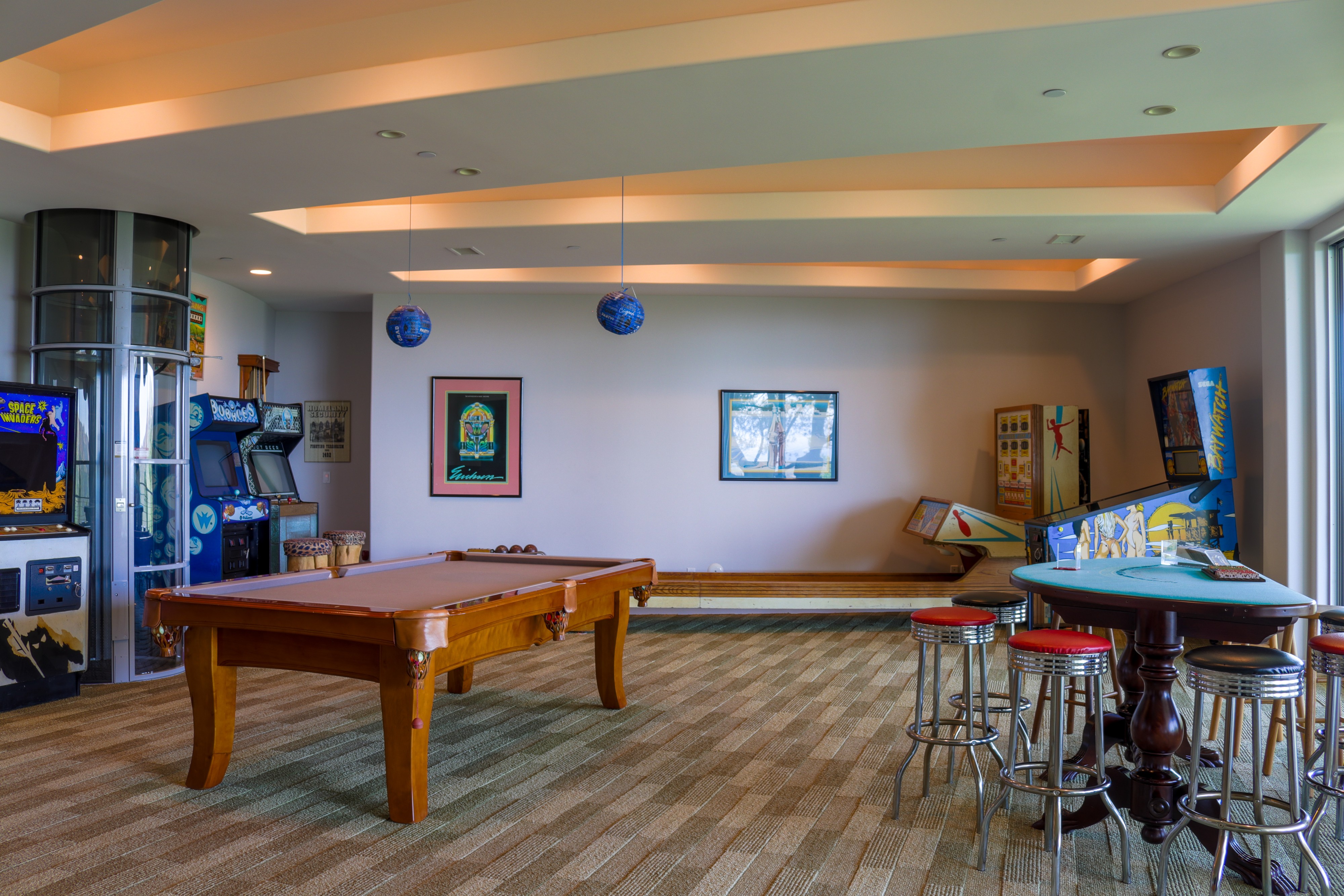 Game room with billiards table and foosball under a coffered ceiling, Tustin hillside home
