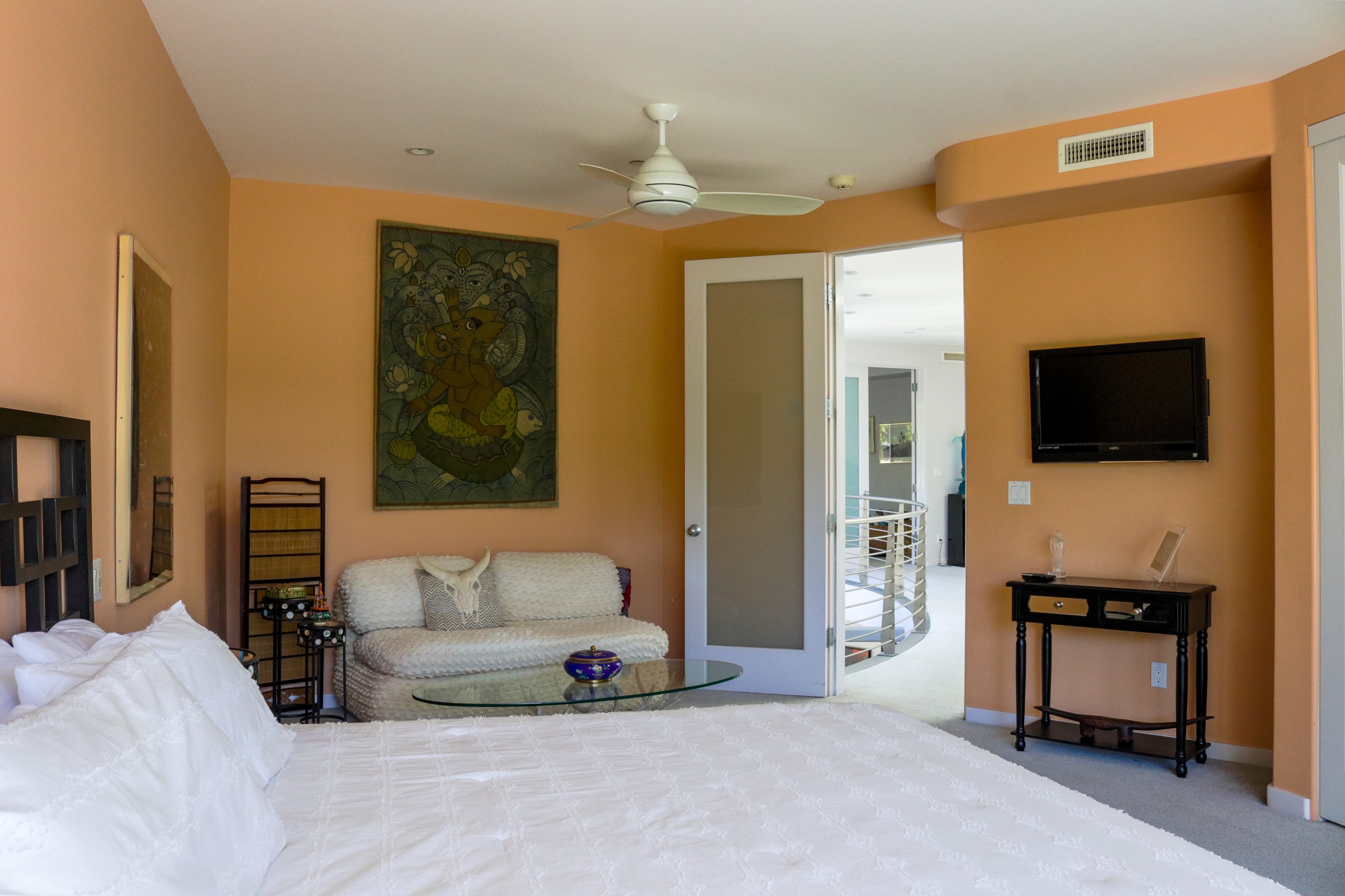 Primary bedroom with artwork and doorway through to the bath, Tustin hillside home