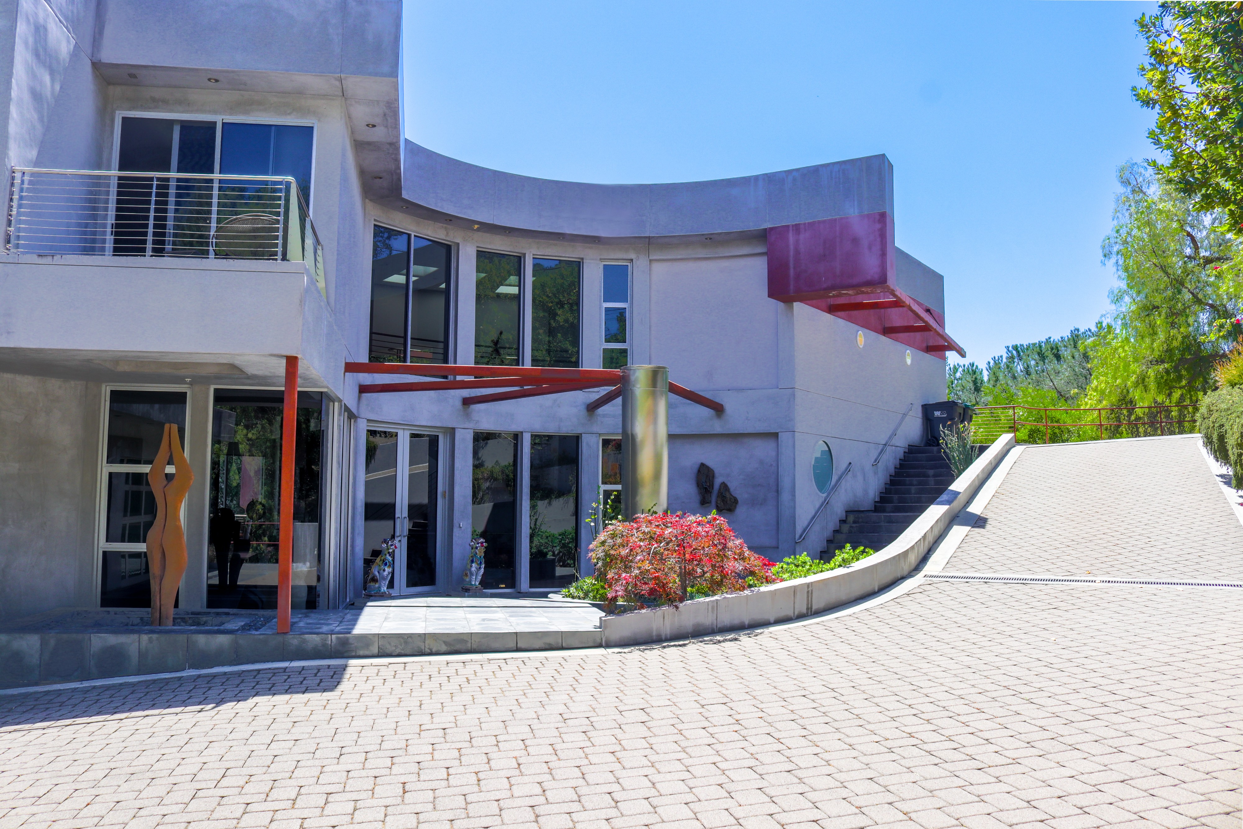 Exterior of a curved modern hillside residence and motor court, Tustin luxury listing