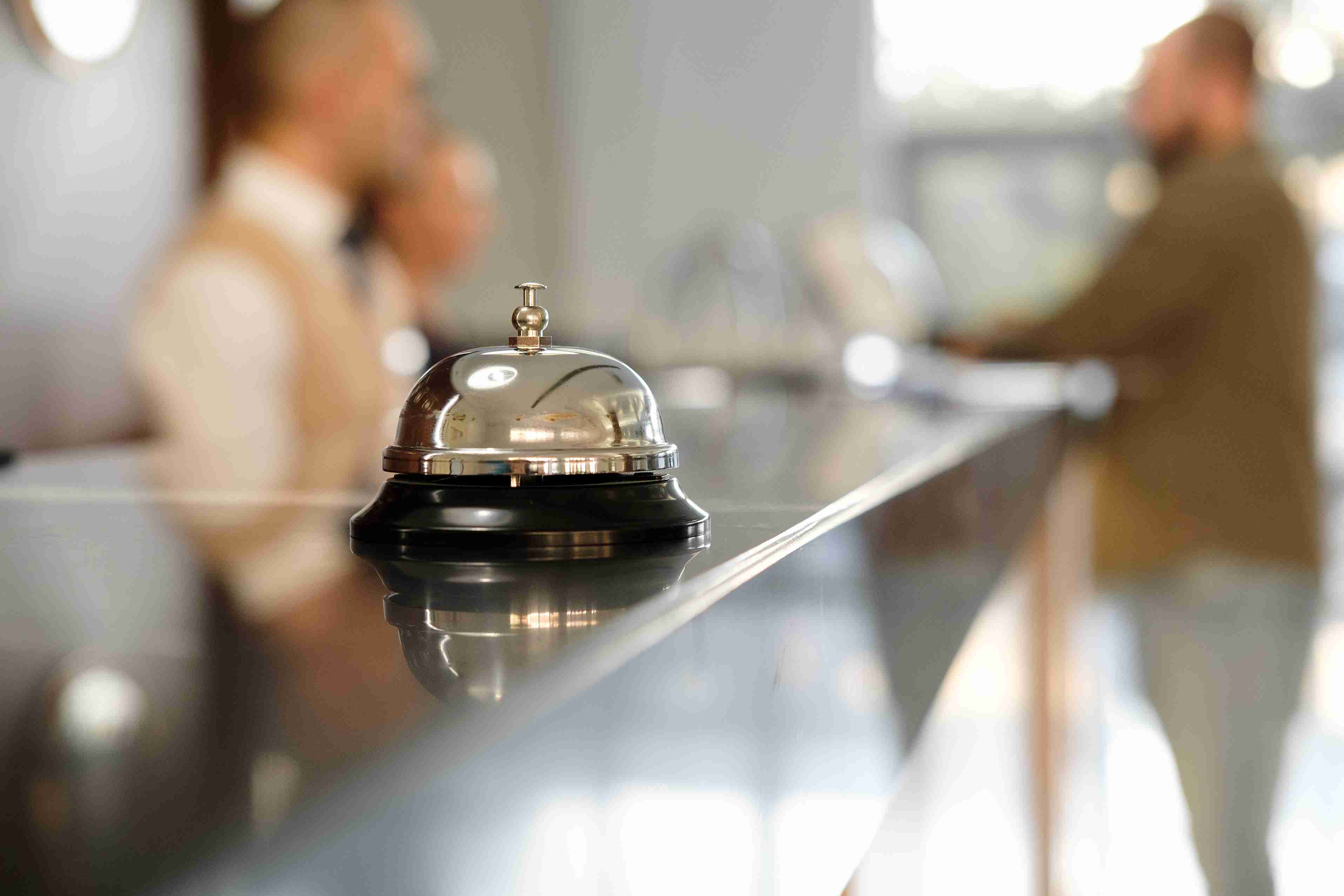 Service bell on a hotel front desk as a guest checks in