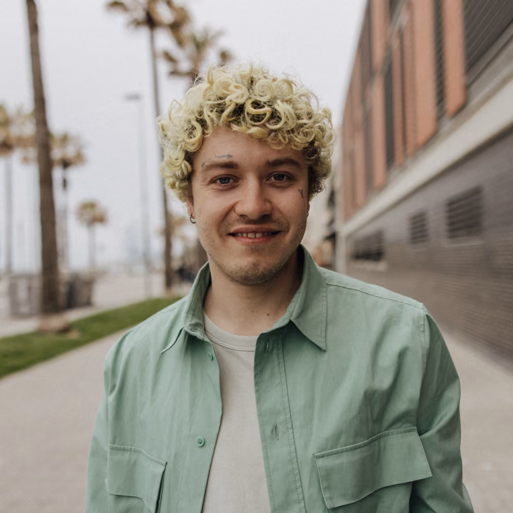 Confident non-binary person in a natural, warmly lit portrait
