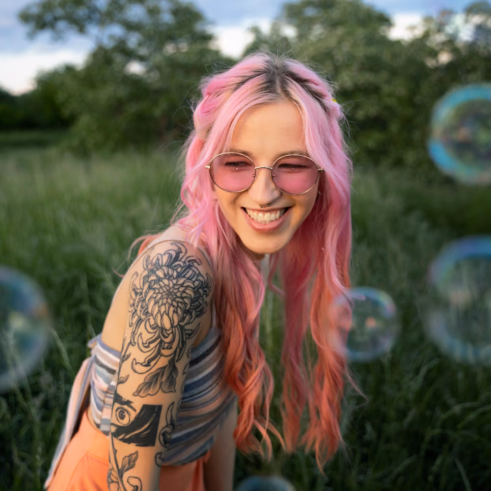 Confident non-binary person in a natural, warmly lit portrait