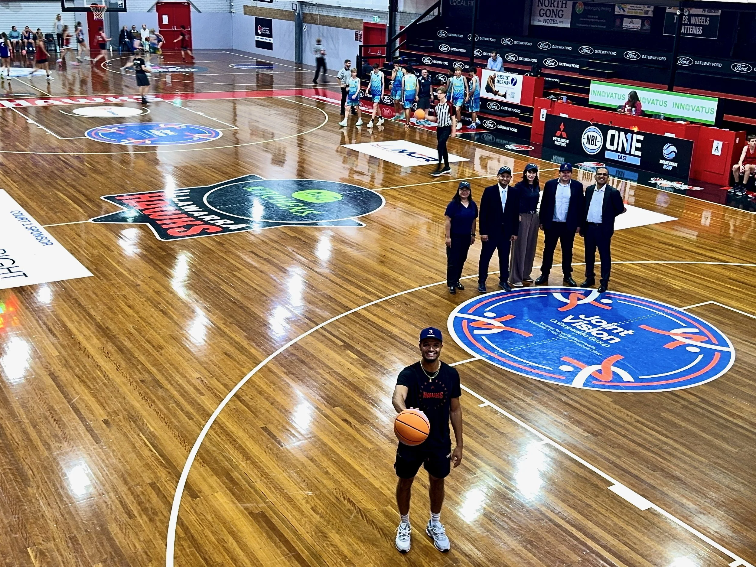 Matt Mims at the Illawarra Basketball Association Snakepit court with Joint Vision Orthopaedic Group centre circle logo during new partnership launch