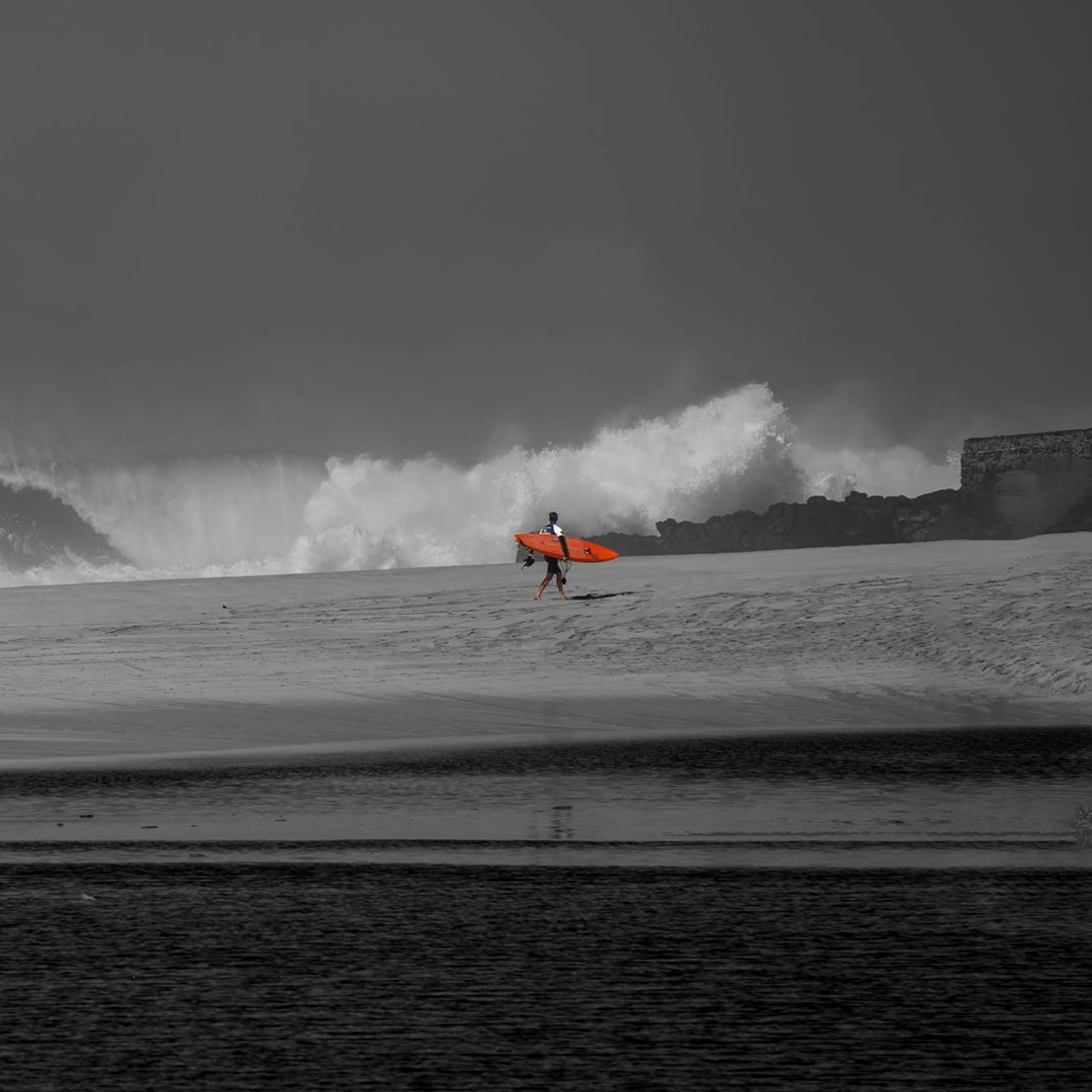 Black and white photo of a surfer on a breaking wave in a stormy ocean