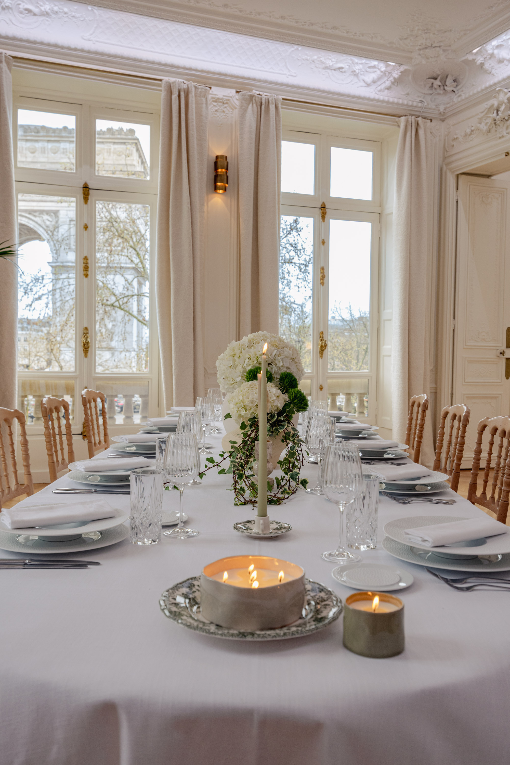 Salon haussmannien du Pavillon Étoile : moulures, fenêtre à crémones dorées et table dressée