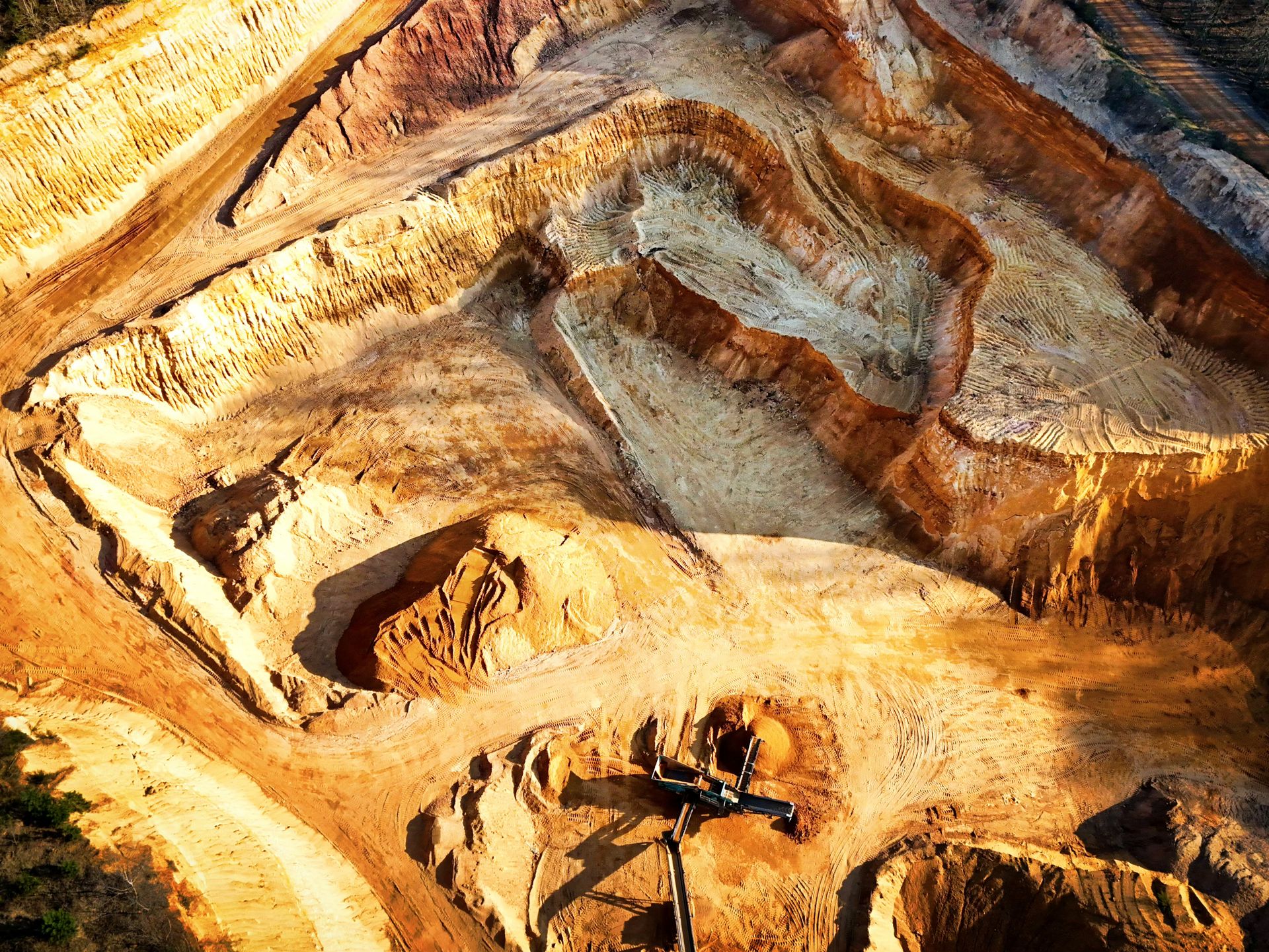 Vista aérea de mina a céu aberto, sem pessoas visíveis, ilustrando extração mineral