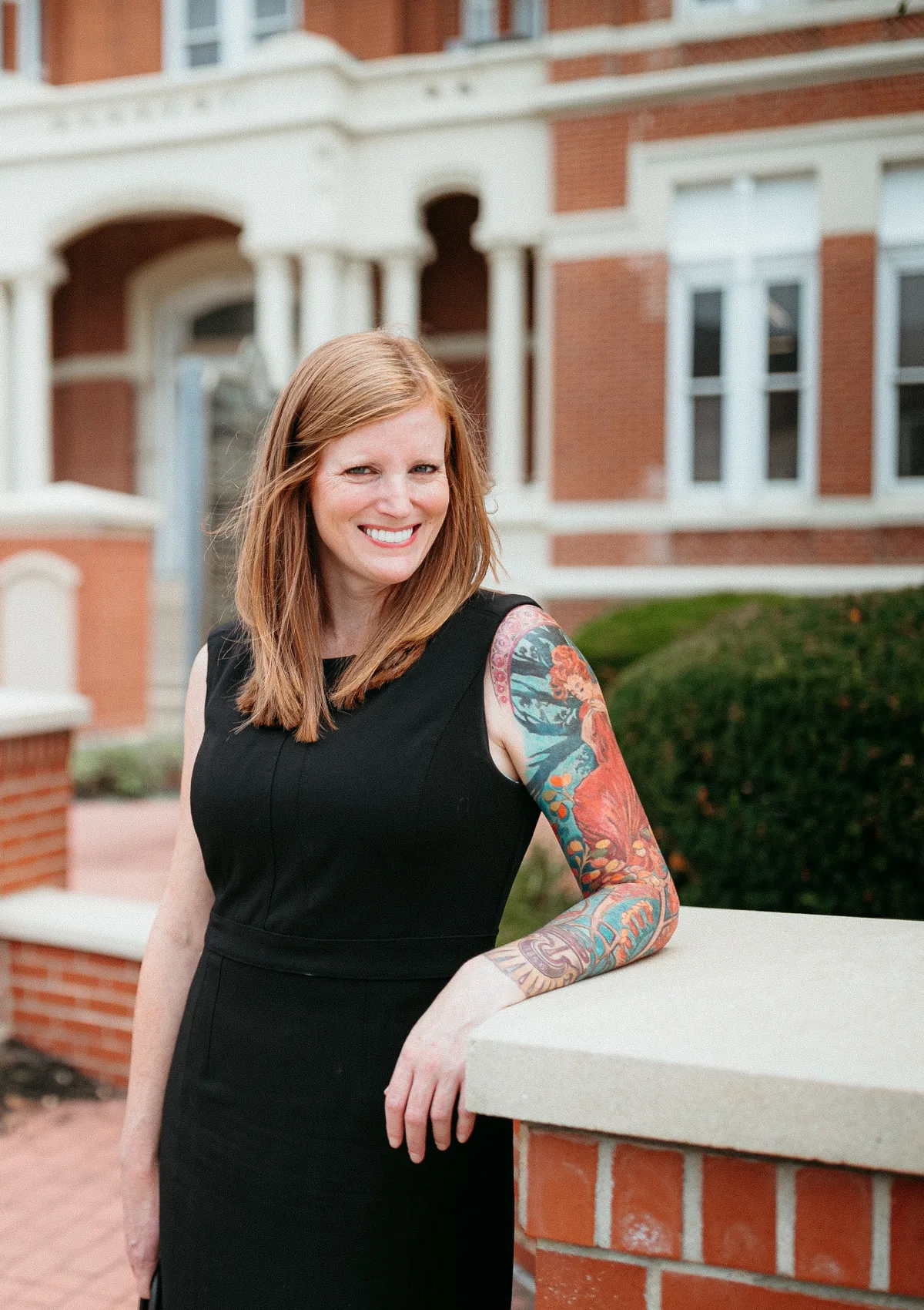 Krista Shelton standing outside a courthouse in a black dress.