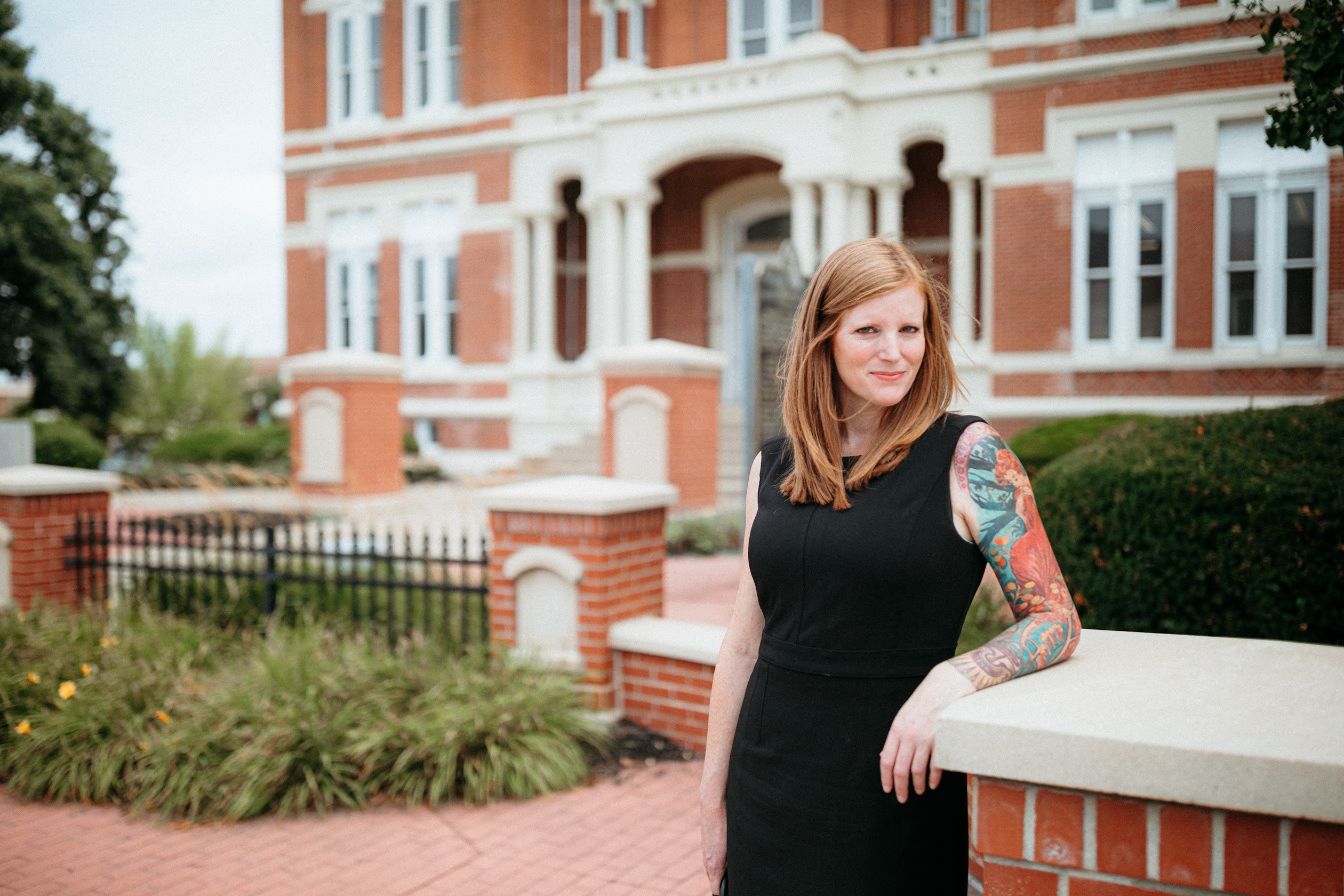 Krista Shelton standing outside a courthouse in a black dress.