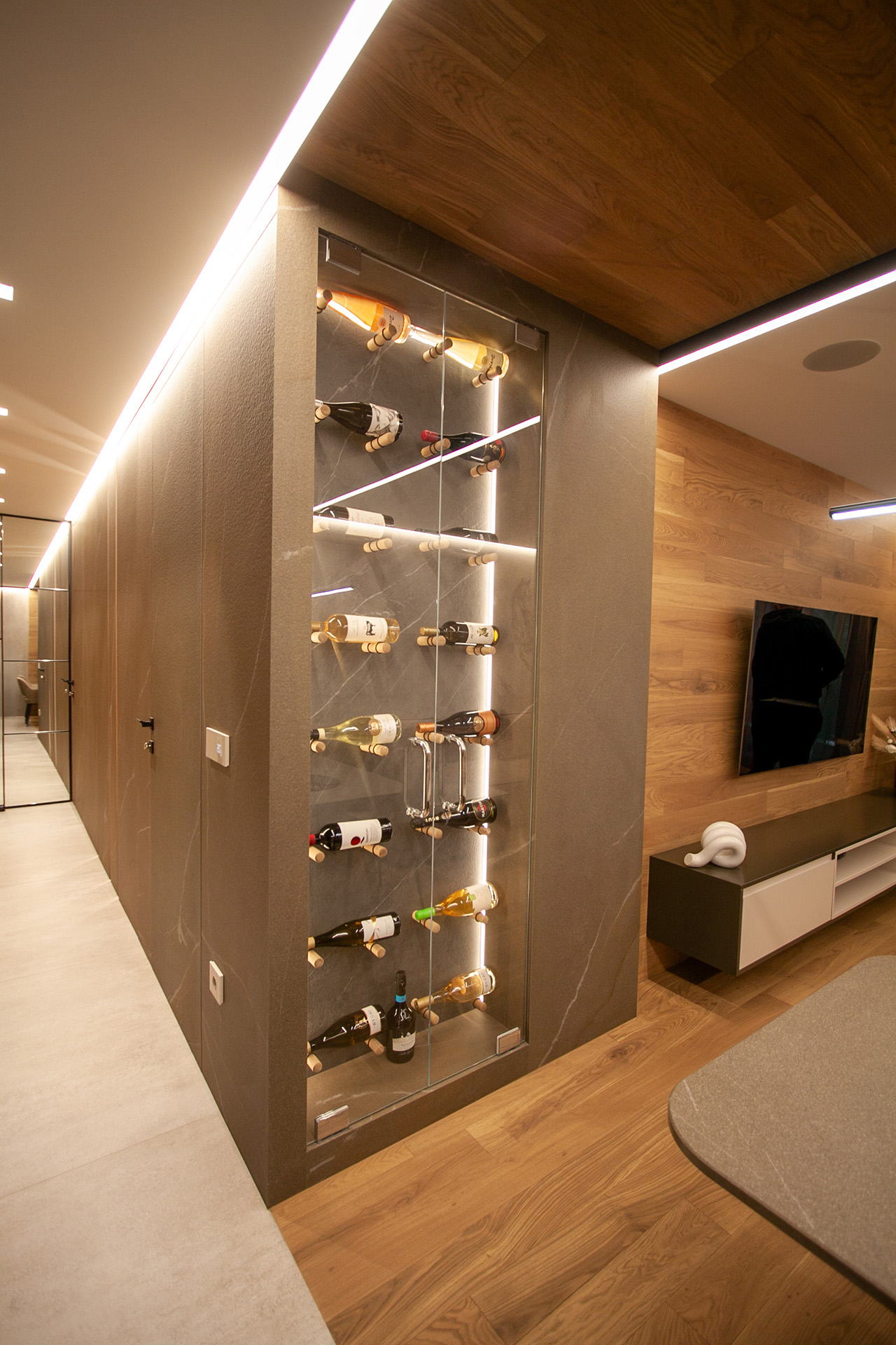 Kosanin Dol Apartament — lit wine display along the corridor