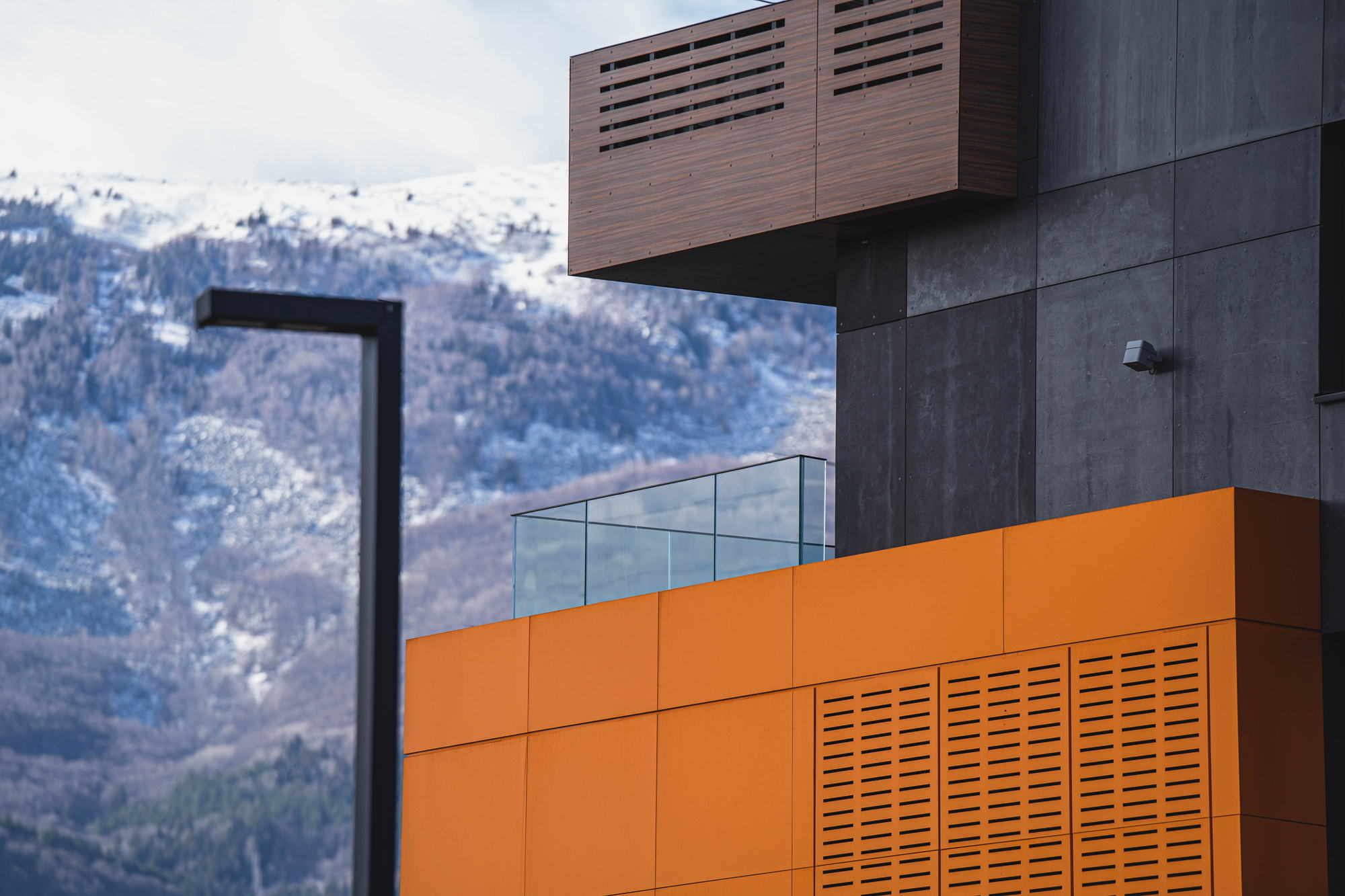 RUhouse — orange louvre panel against the mountain