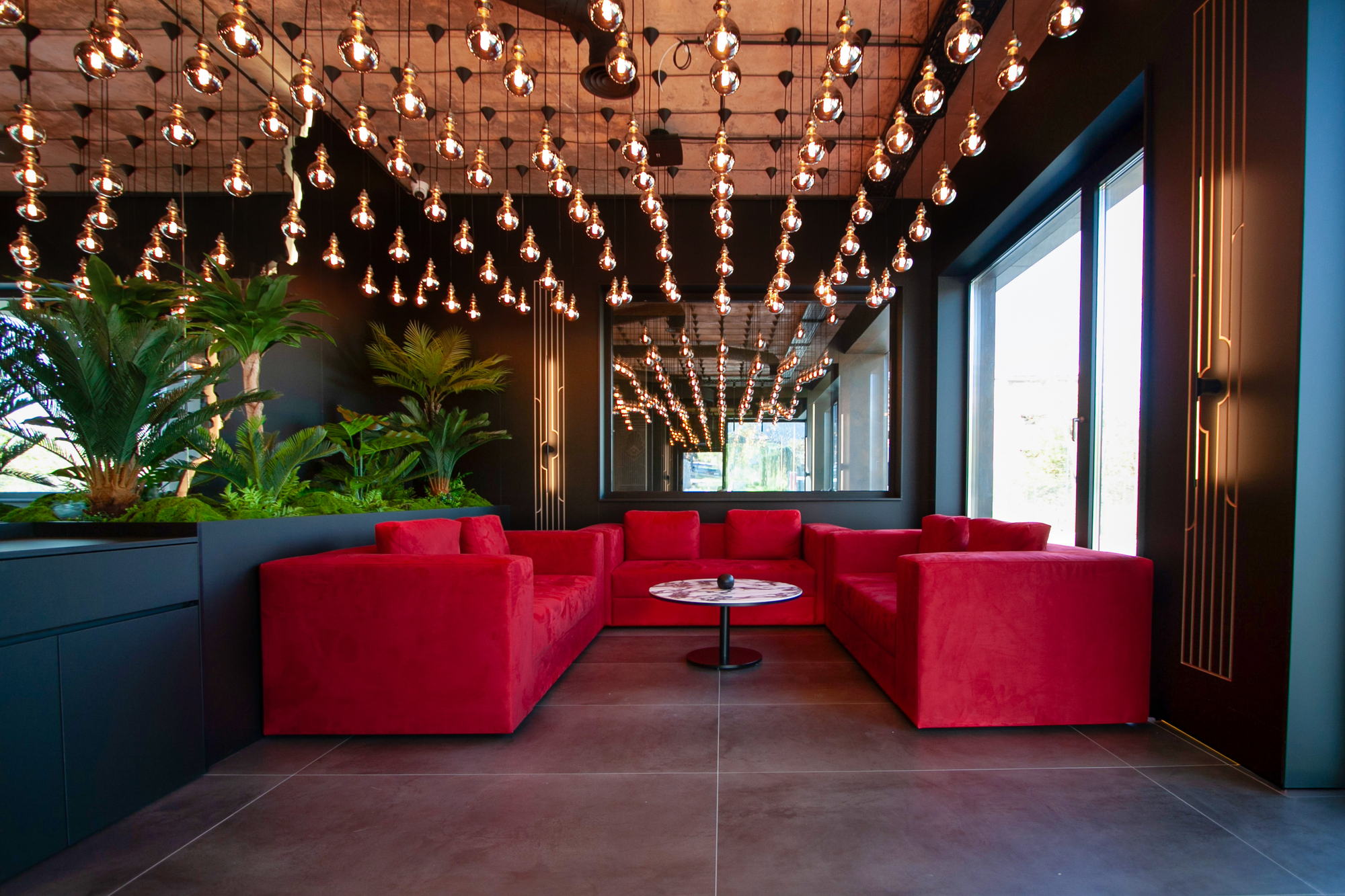 The Royal Residence — lounge with red seating under the bulb ceiling