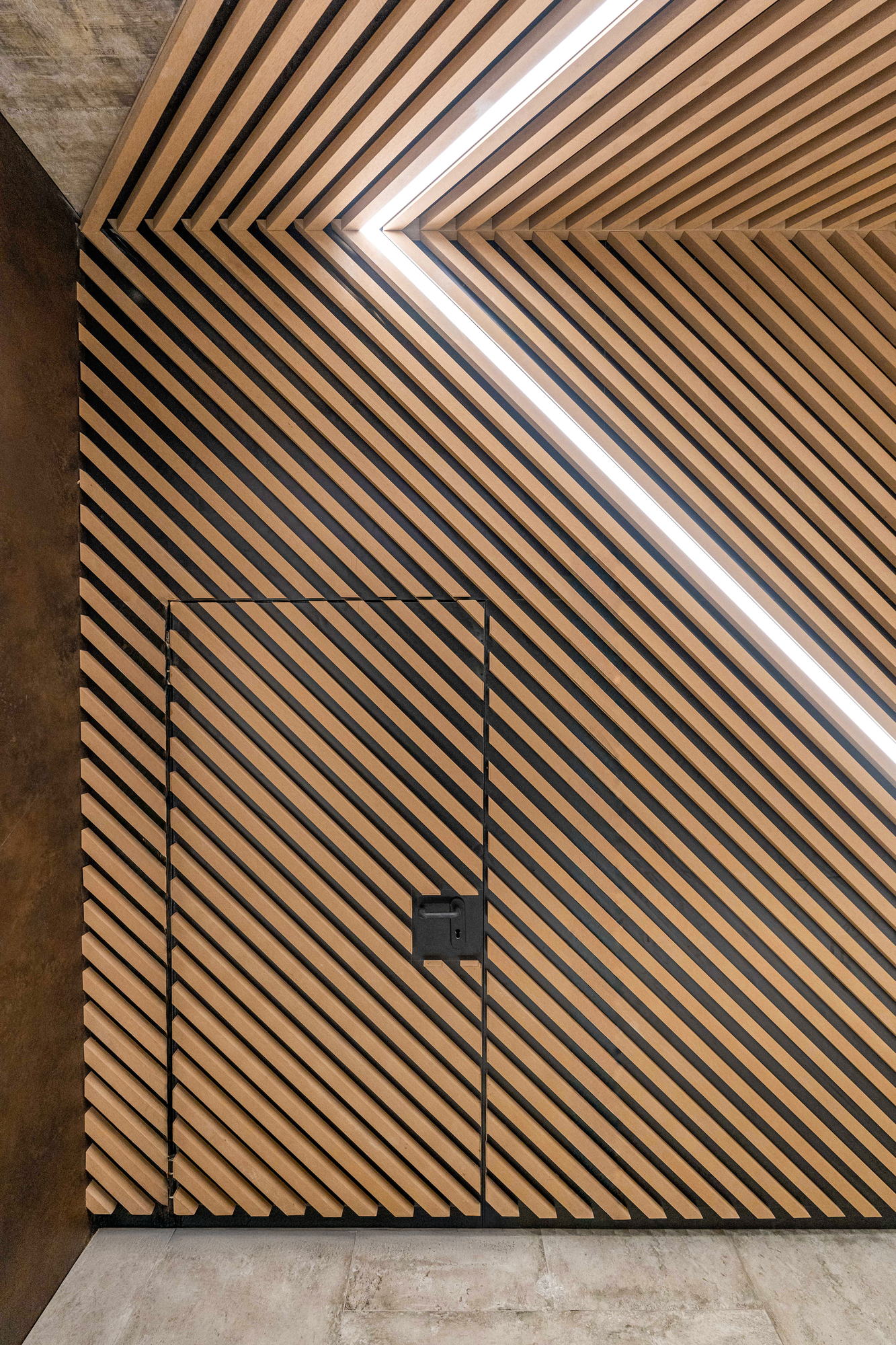 RUhouse II — foyer, chevron timber batten wall with a recessed light line