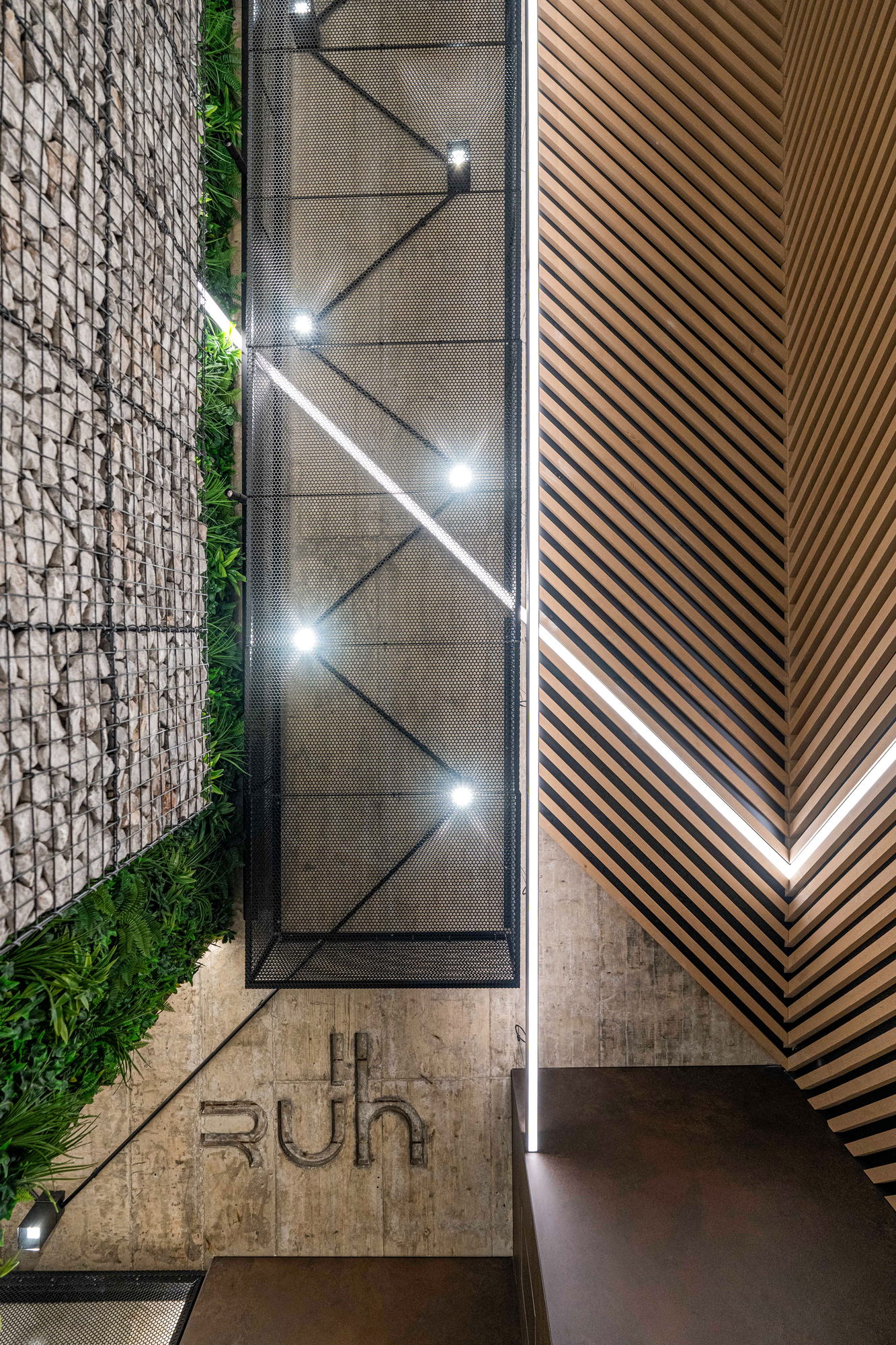 RUhouse II — foyer, gabion wall and timber battens with the RUh sign