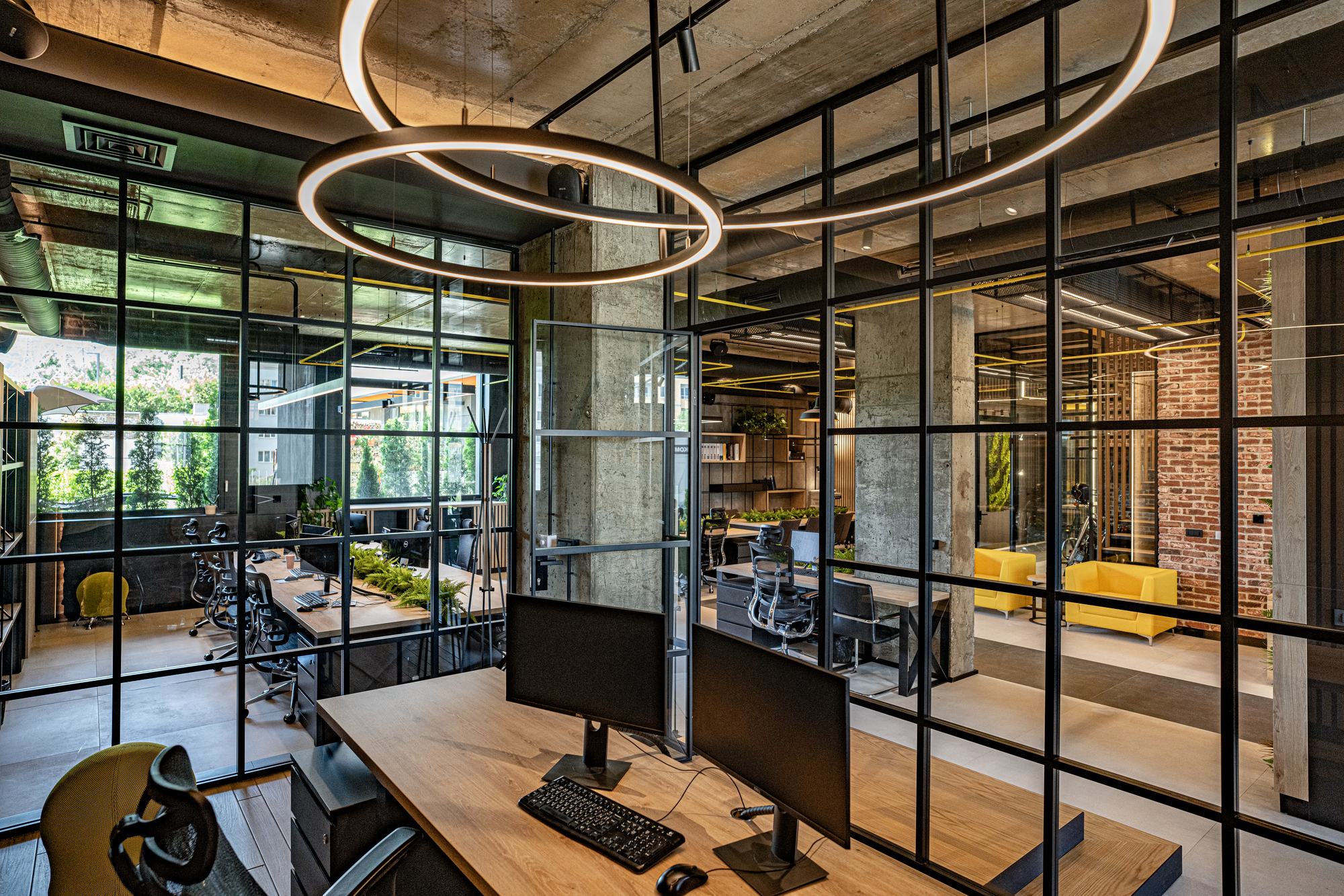 Comfort Partners Headquarters — ring pendants over the desks and black-framed glazing to the courtyard