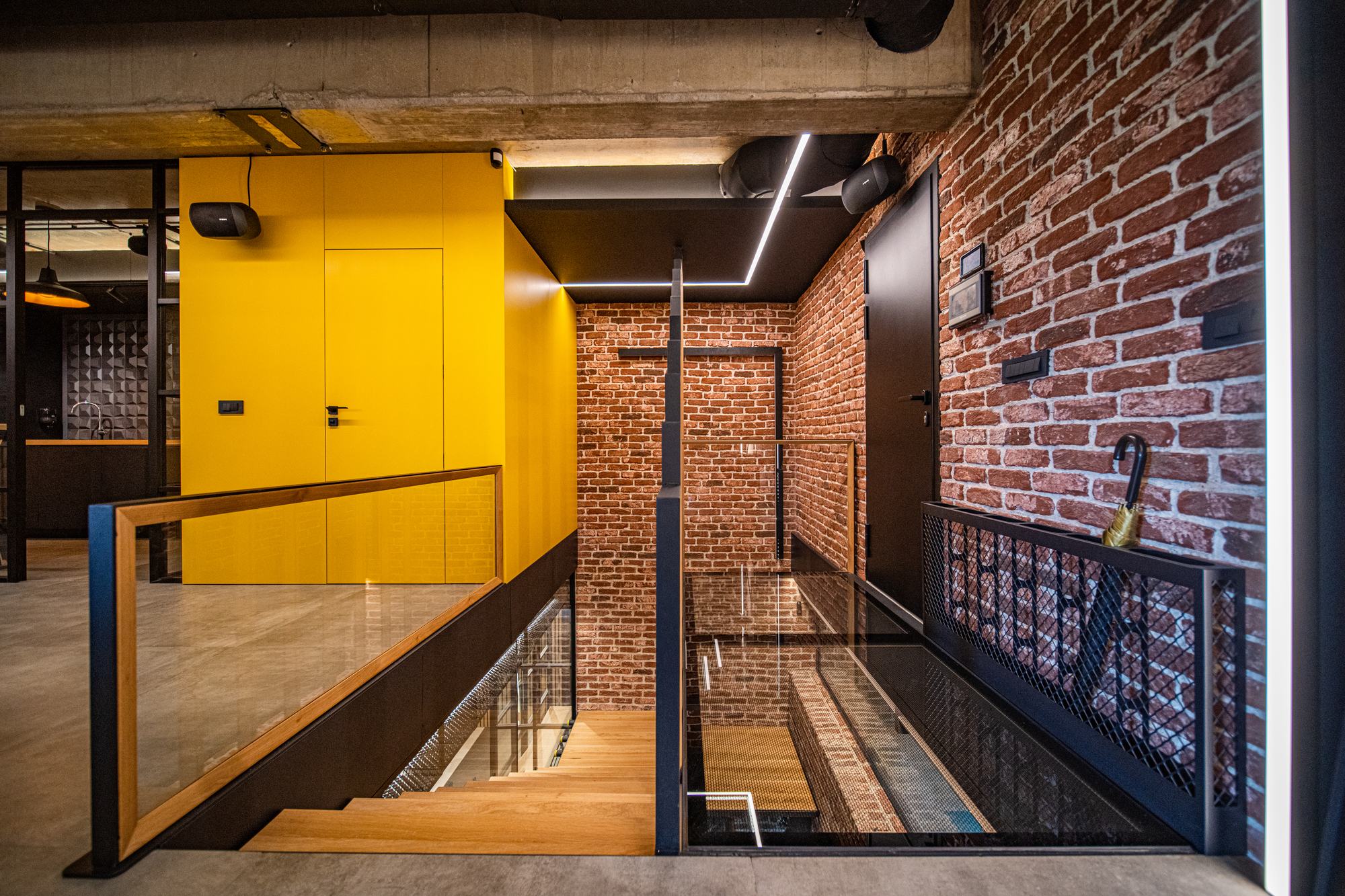 Comfort Partners Headquarters — the stair landing between the yellow wall and the brick