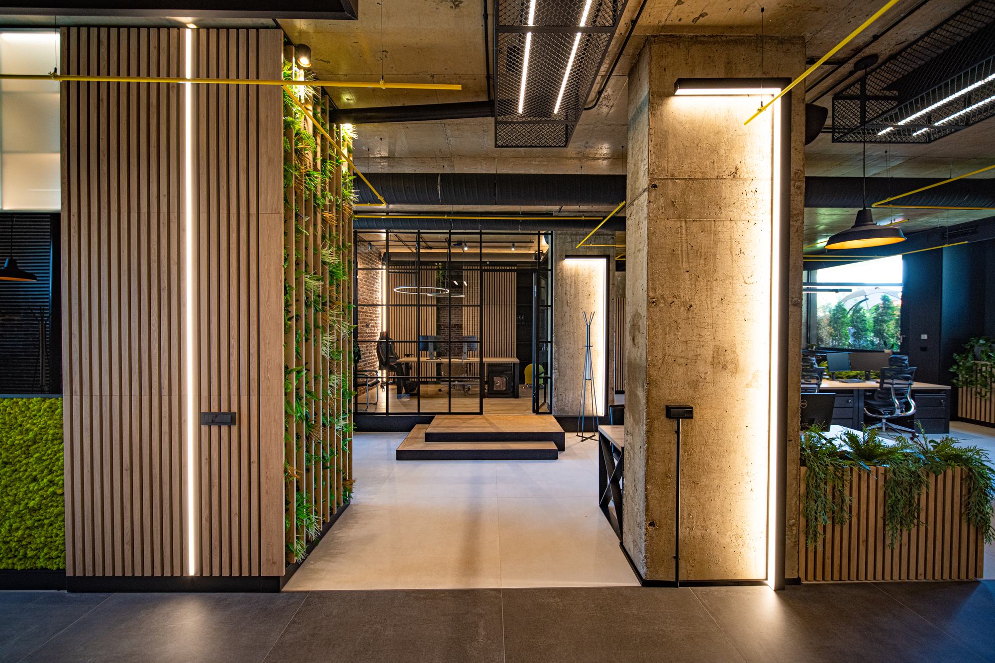 Comfort Partners Headquarters — timber-slatted partitions and moss panels beside a concrete column