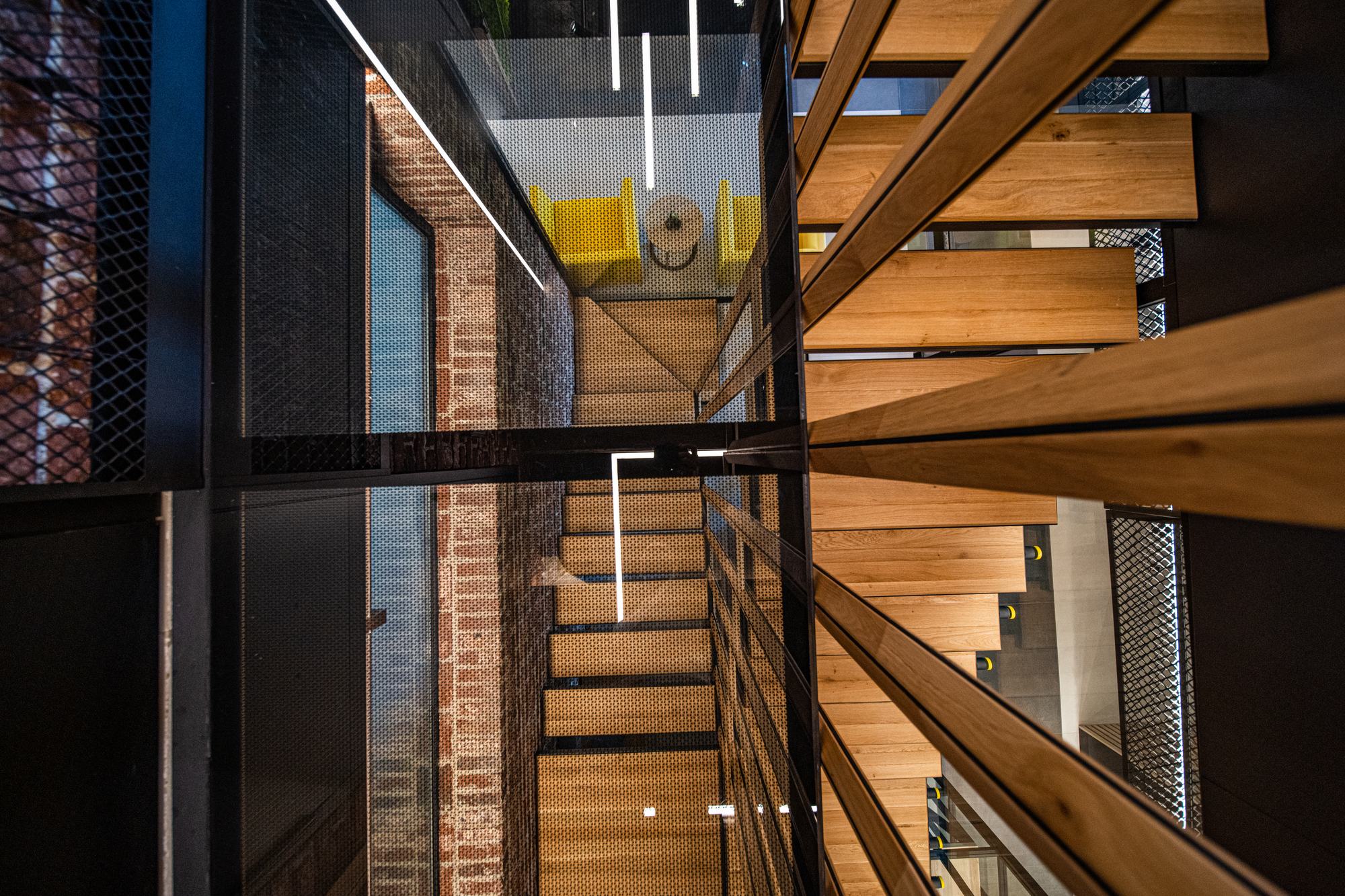 Comfort Partners Headquarters — looking up the suspended stair through the glass floor