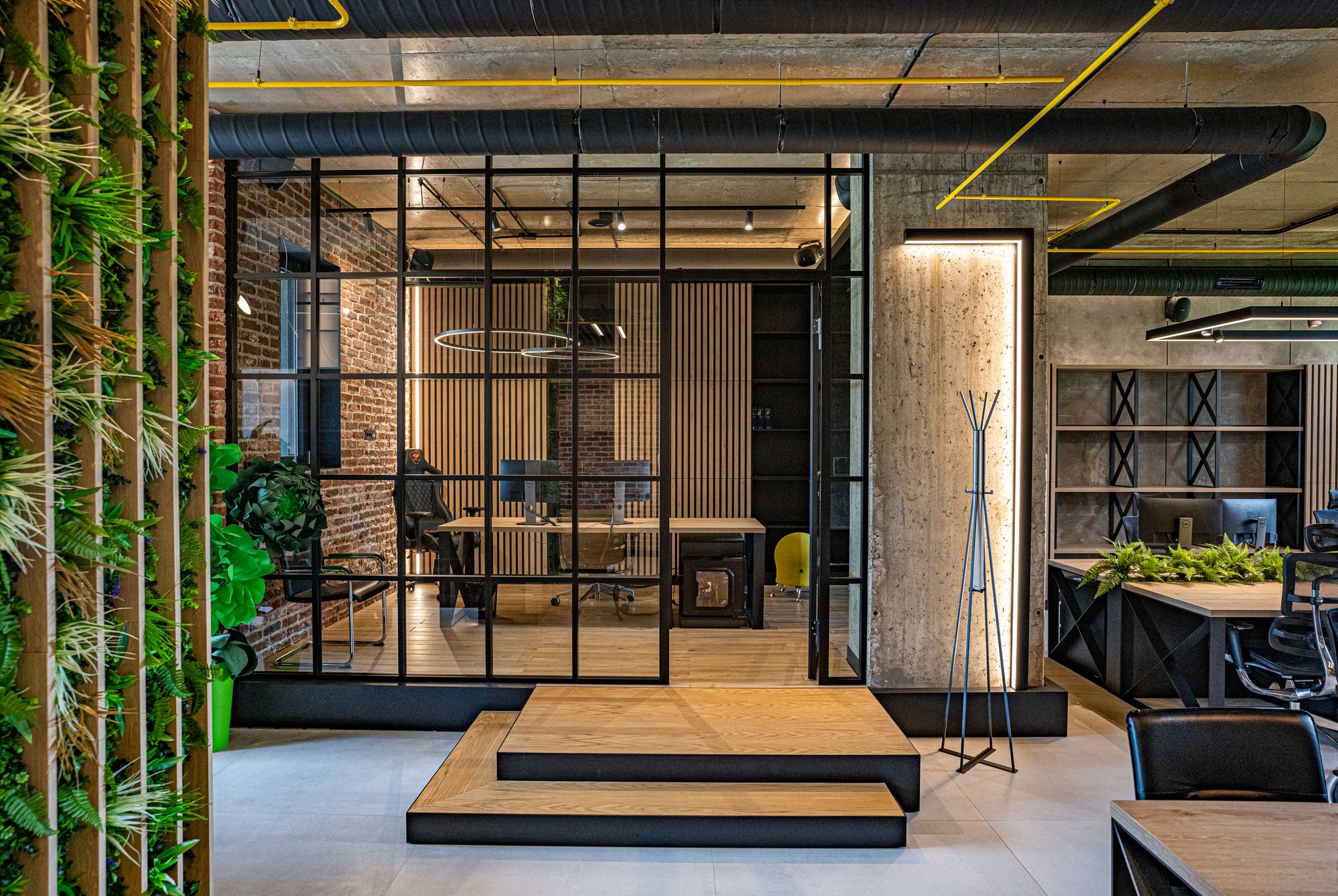 Comfort Partners Headquarters — glazed meeting room in black steel with a timber platform